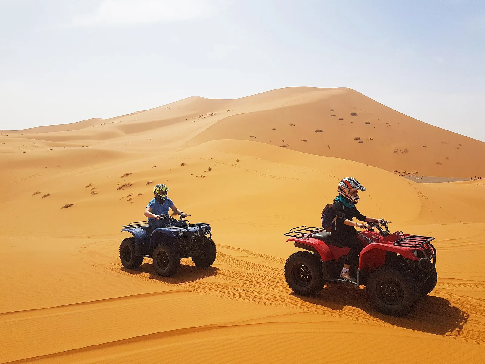 Quad riders crossing sand dunes in Morocco