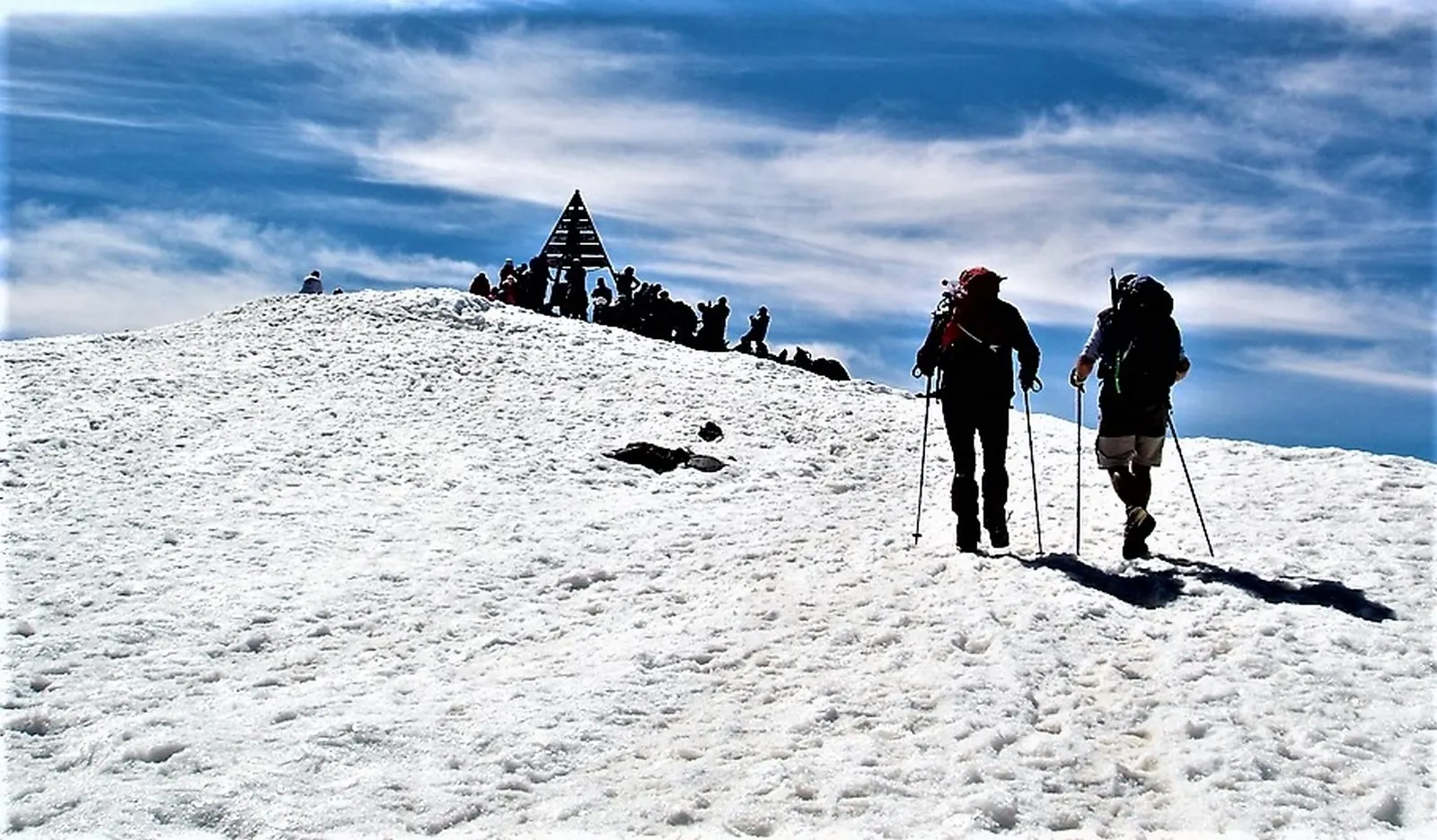 Two hikers walking across snow near the Tizi n'Toubkal pass