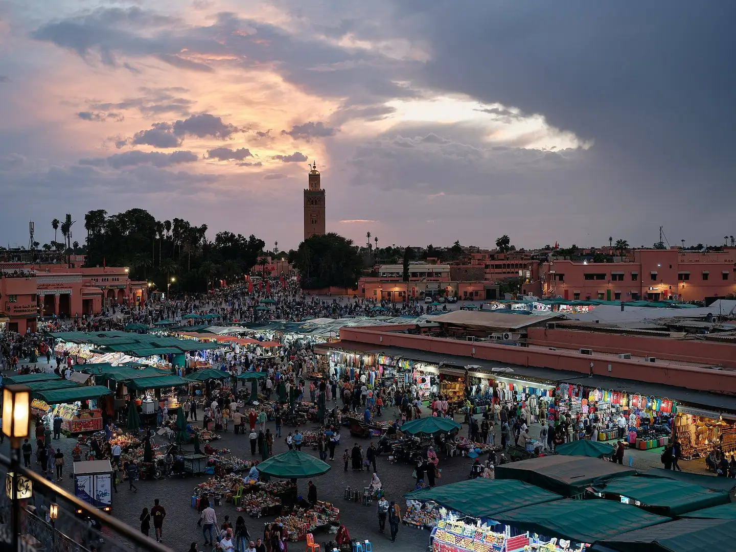 Jemaa el-Fna square at sunset with the Koutoubia minaret in the distance