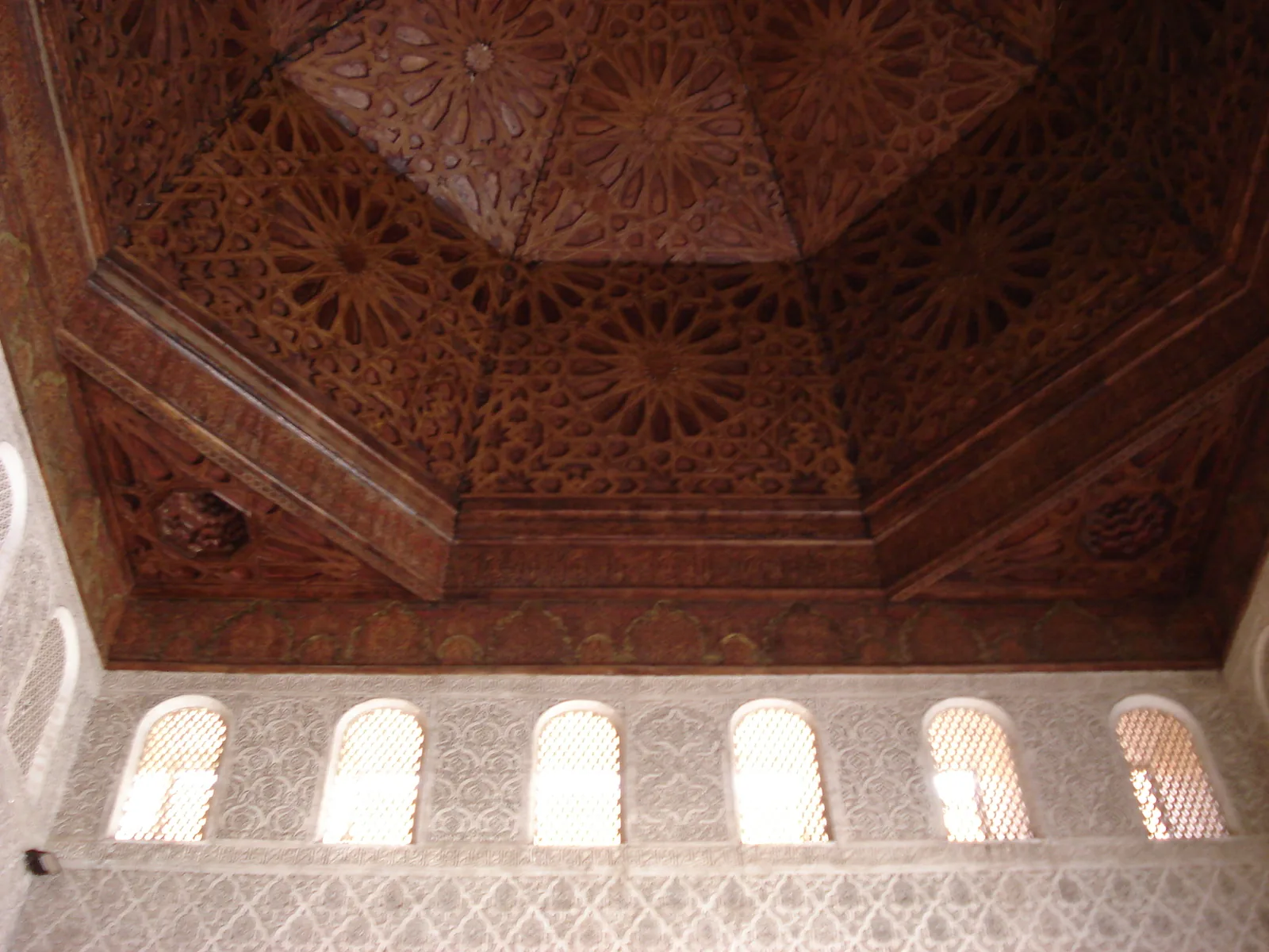 A carved cedar wood ceiling in the Ben Youssef Madrasa