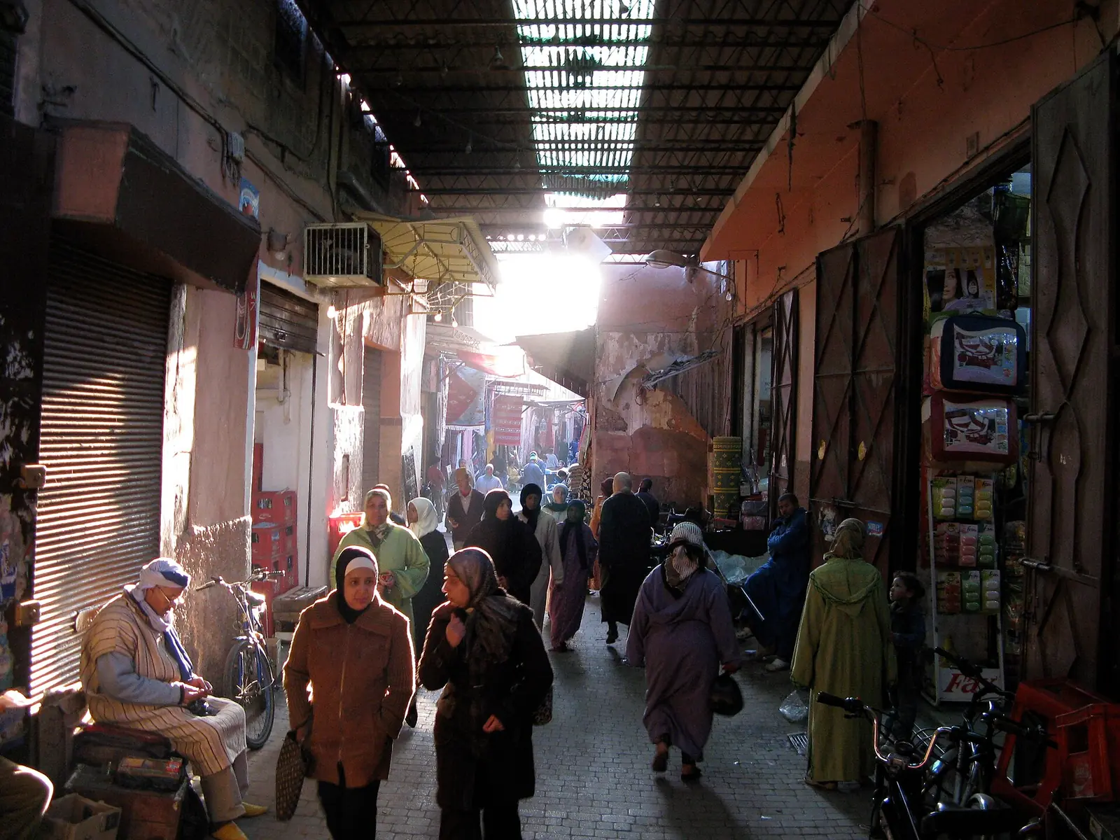 Shoppers walking through a covered lane in the Marrakech souks