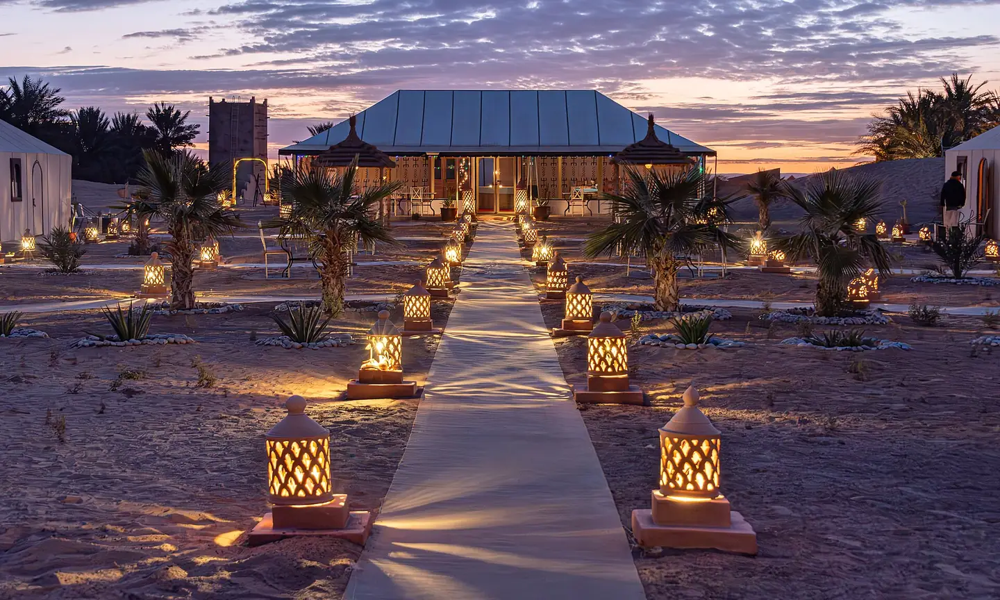 Lantern-lit luxury desert camp at dusk