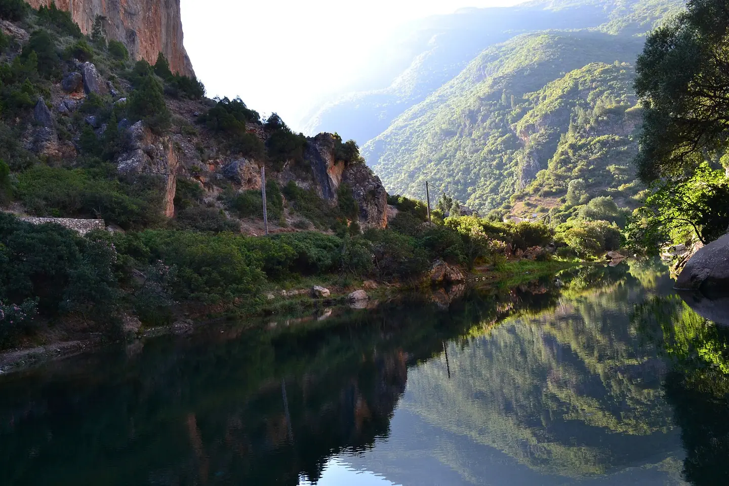 Still water mirroring the cliffs of the Akchour gorge