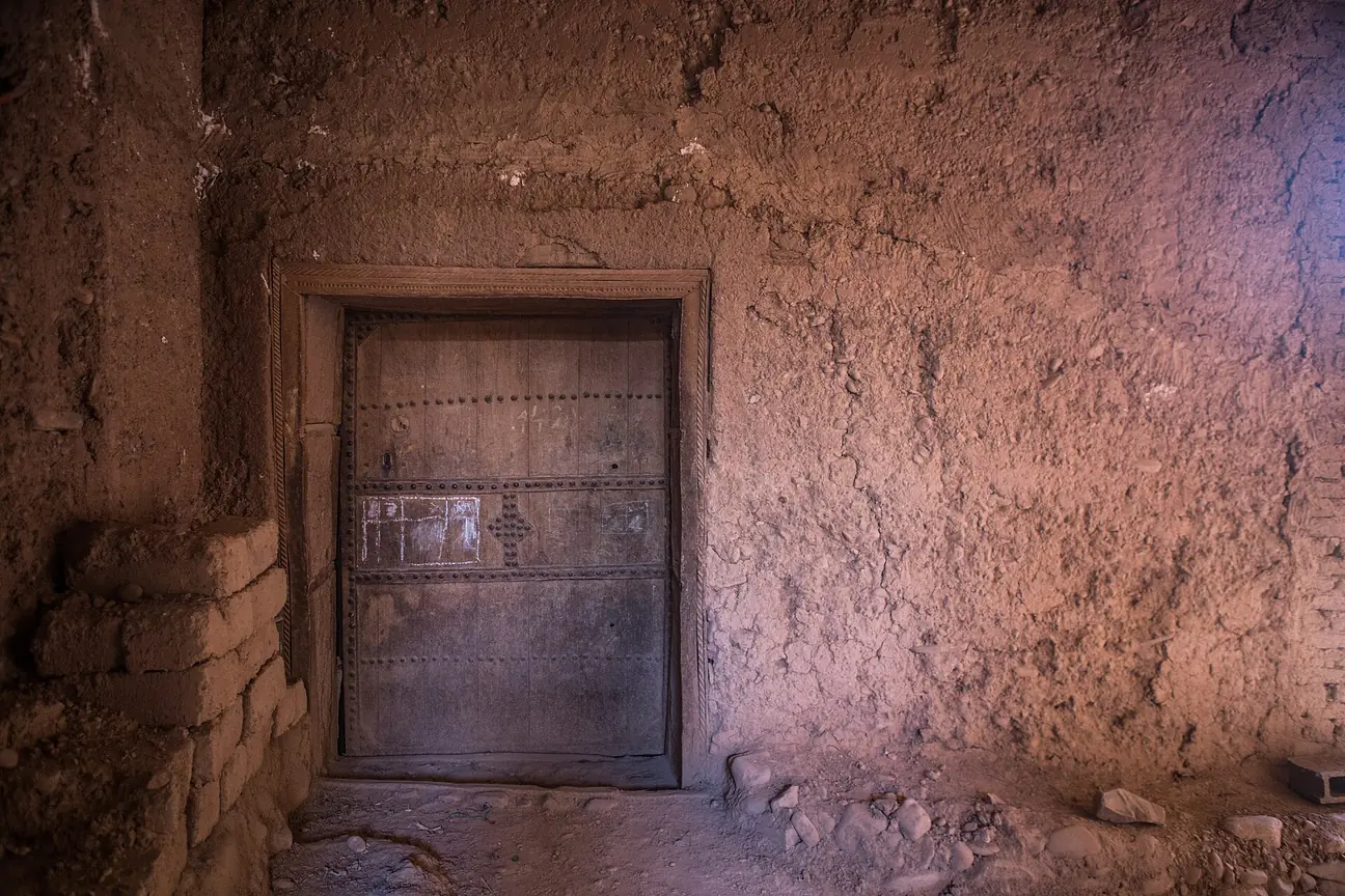 An old wooden door in a mud-brick wall at Ksar Tighit