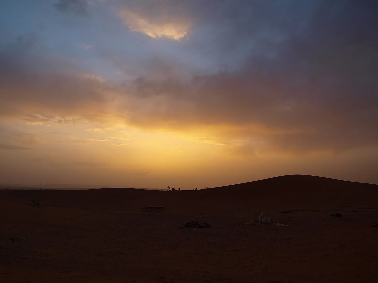 Sunrise breaking through clouds over Erg Chigaga