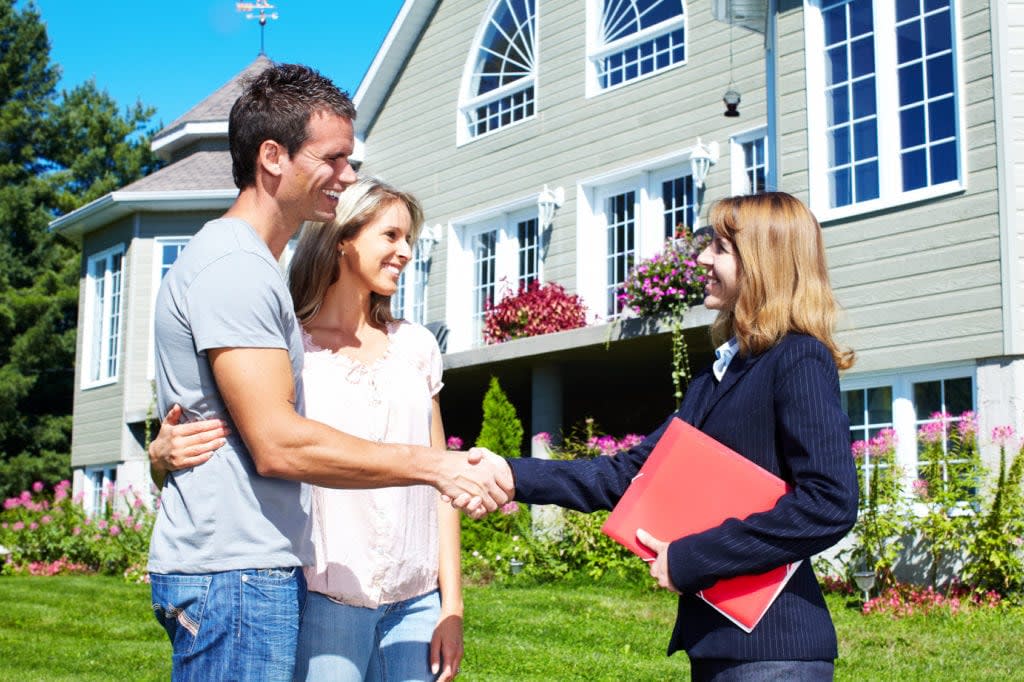 Happy family with agent realtor near new house.