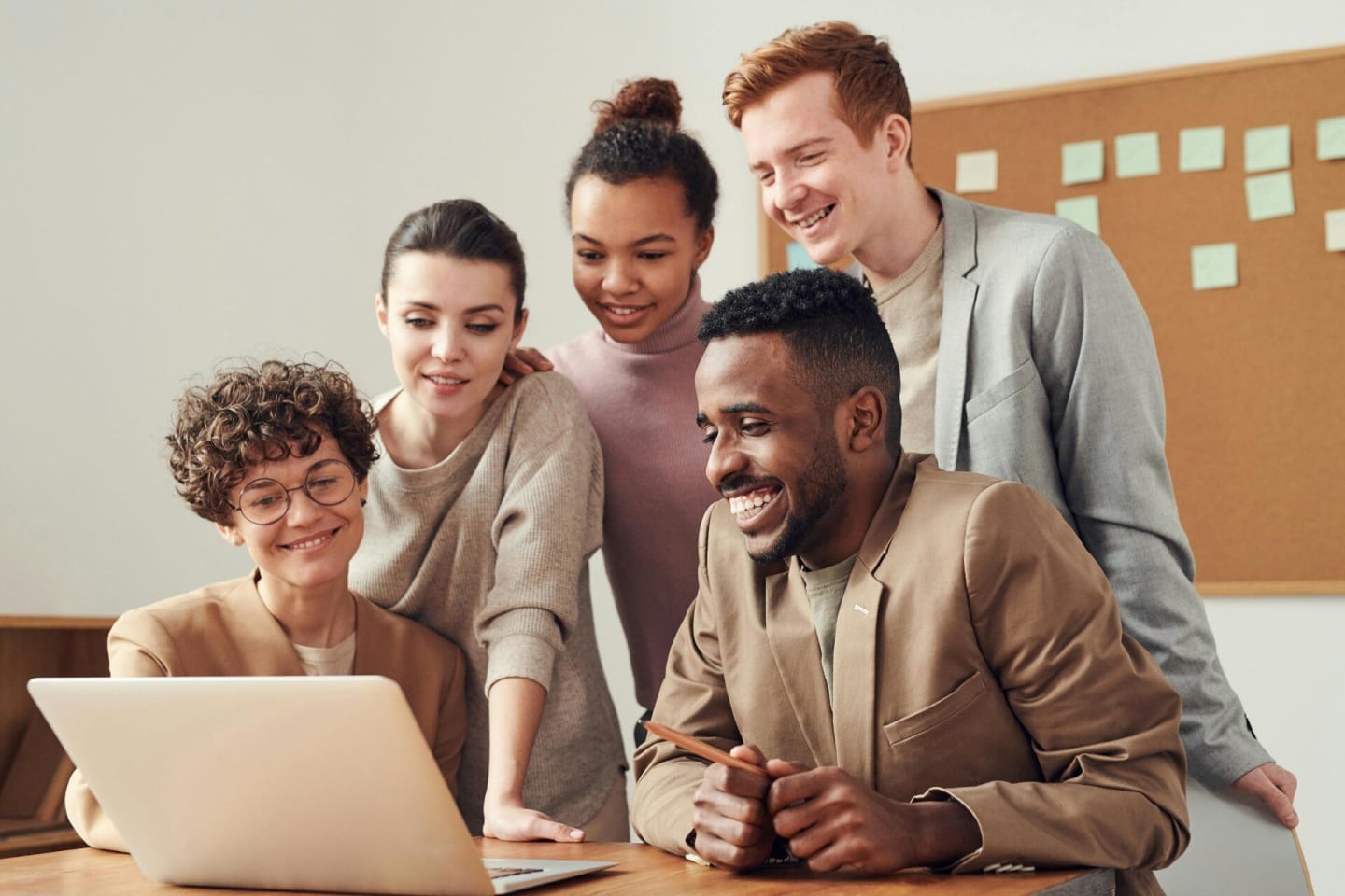 Groep jonge collega's lachen samen in een online overleg