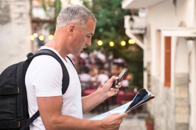 Man checking his phone and a map while traveling