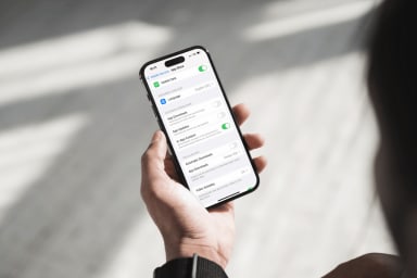 A person holding a phone with the App Store settings view open