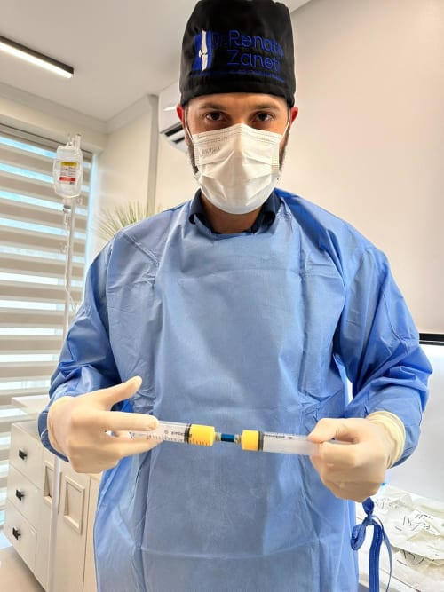 Close das maos do Dr. Renato com a seringa durante o procedimento