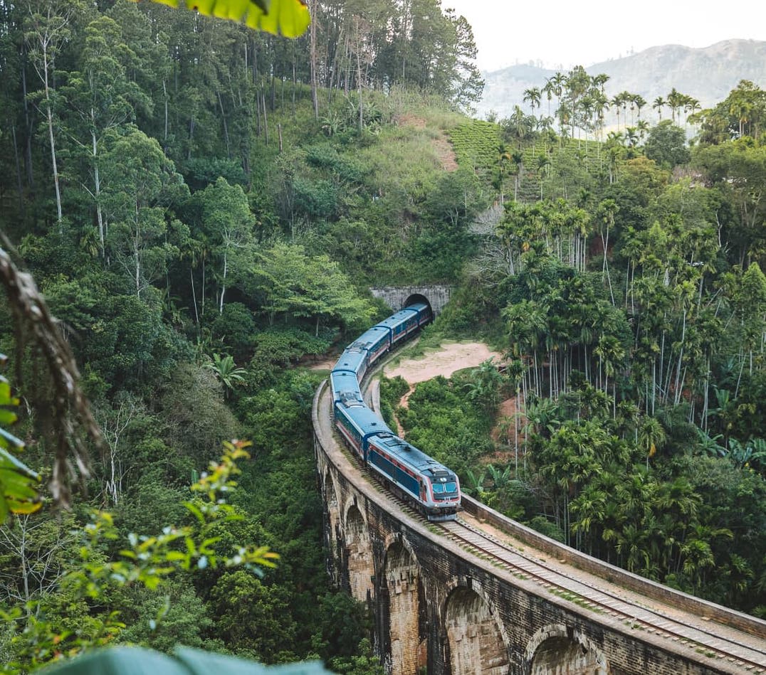 A blue train crossing the Nine Arch Bridge near Ella in Sri Lanka's hill country