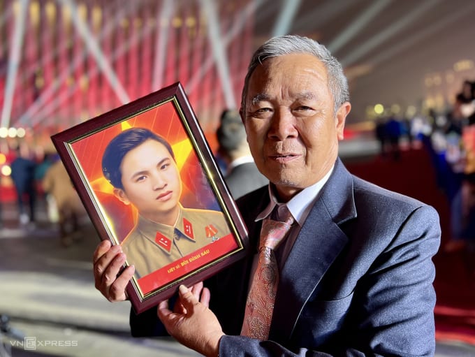 Ông Bùi Đình Năm nhận di ảnh liệt sĩ Bùi Đình Sáu, hôm nay, hài cốt liệt sĩ chuyển từ Tây Ninh về tới quê nhà xã Phúc Lộc, Hà Nội. Ảnh: Hoàng Phương