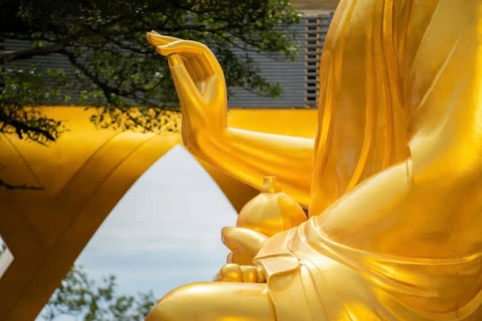 Tay phải Đức Phật Câu Na Hàm thủ ấn giáo hóa, tay trái cầm quả sung. Ảnh: Sun Group