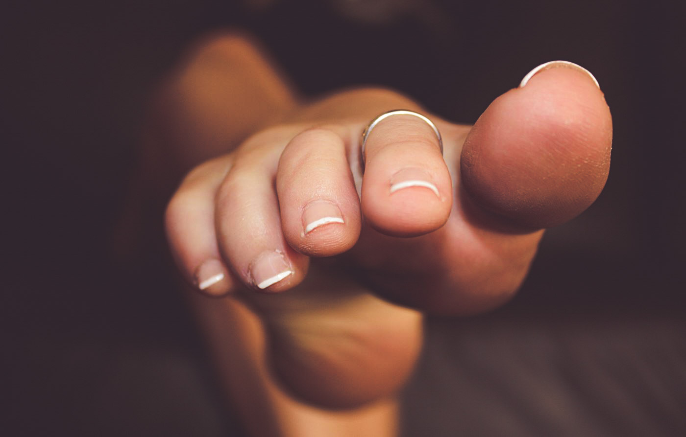 a closeup of a woman pointing her french-manicured toes
