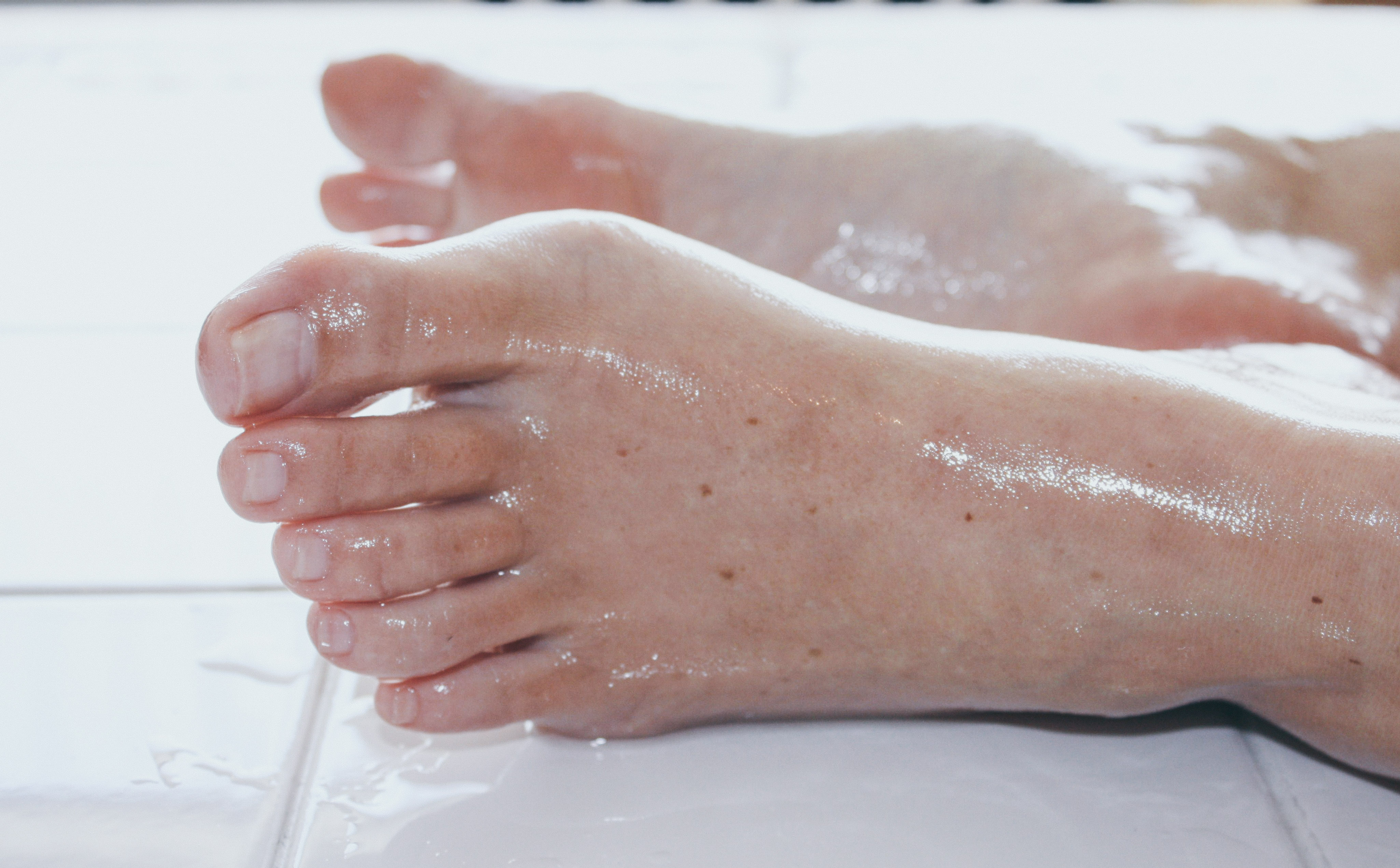 a woman's feet covered in baby oil resting on a table