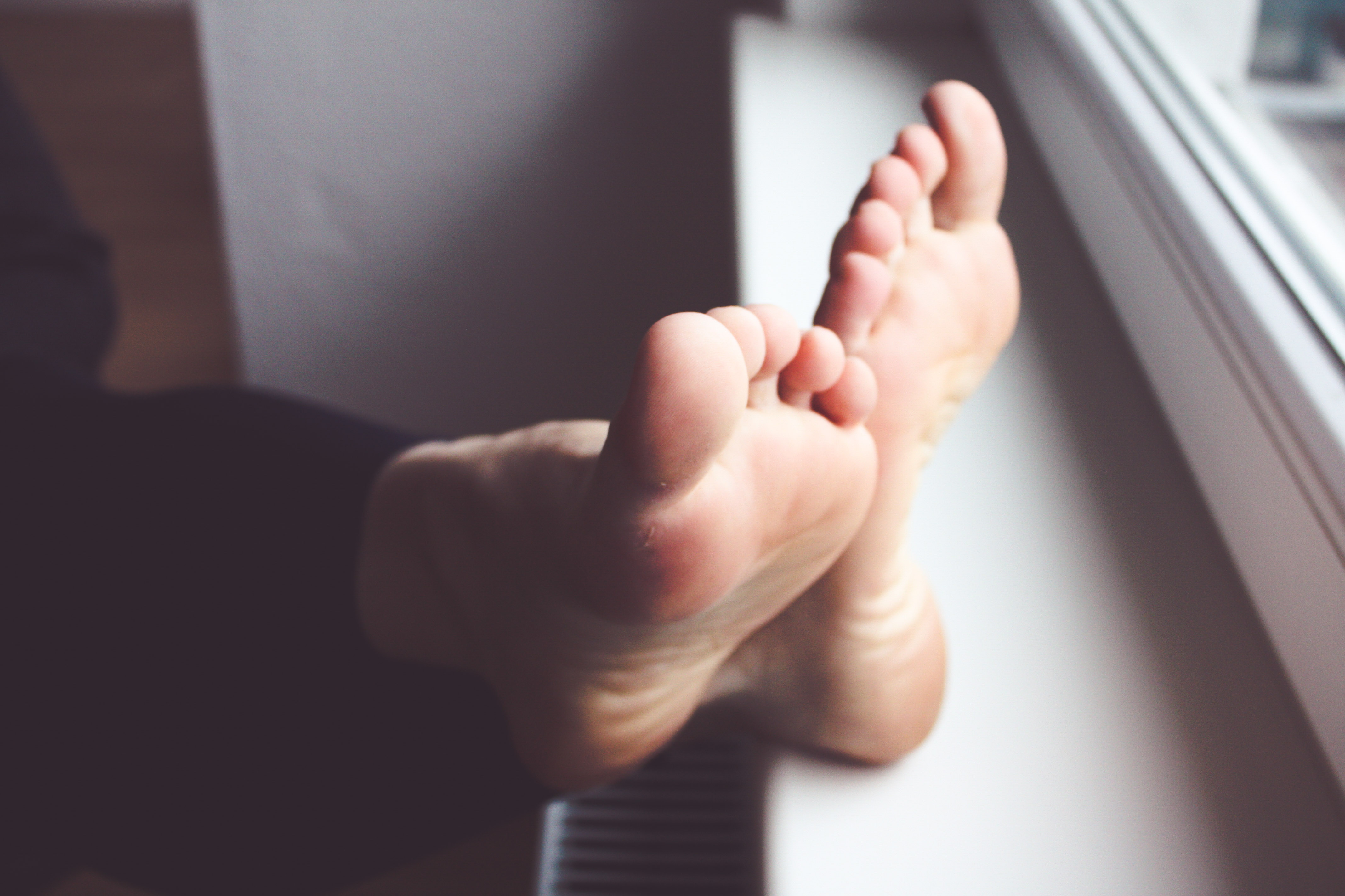 a woman's soles propped up on a windo sill