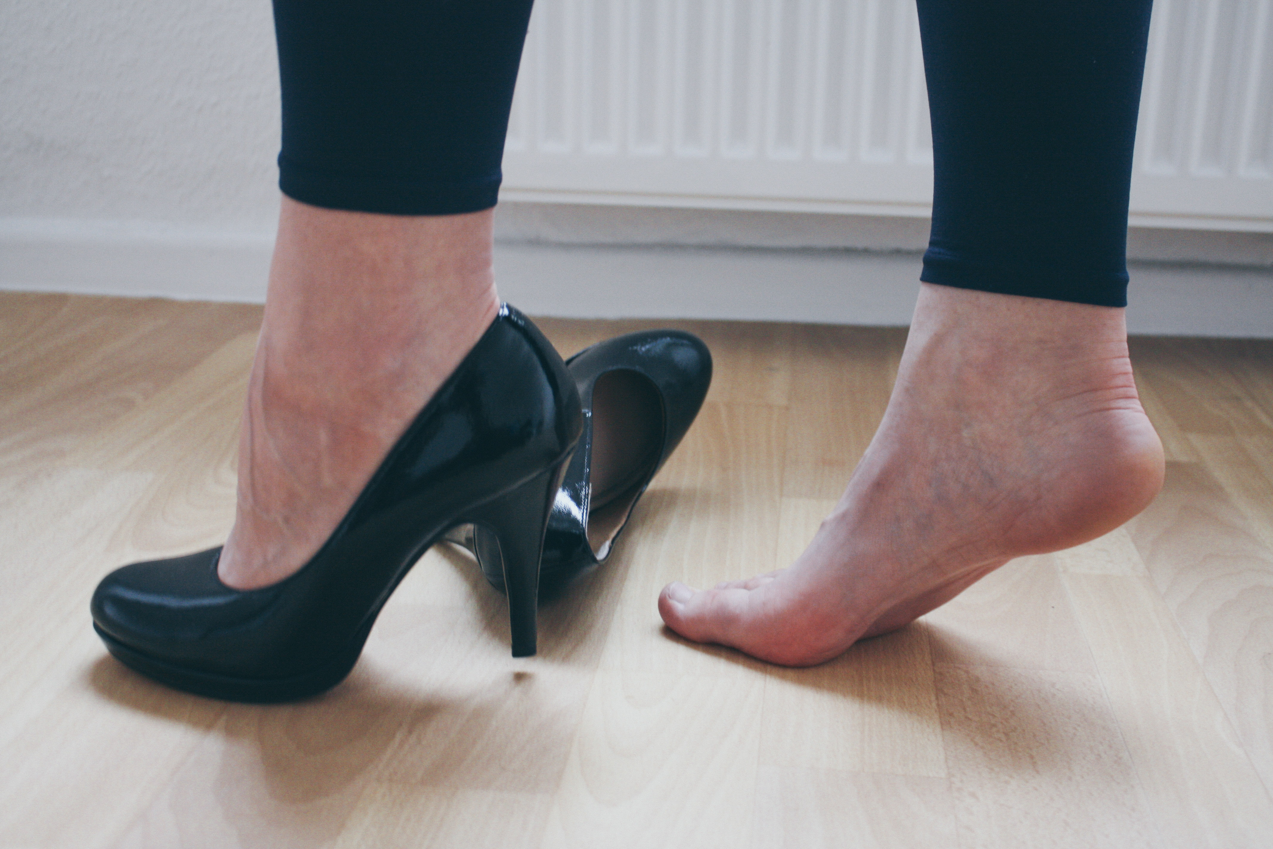 a woman wearing one black high heel 