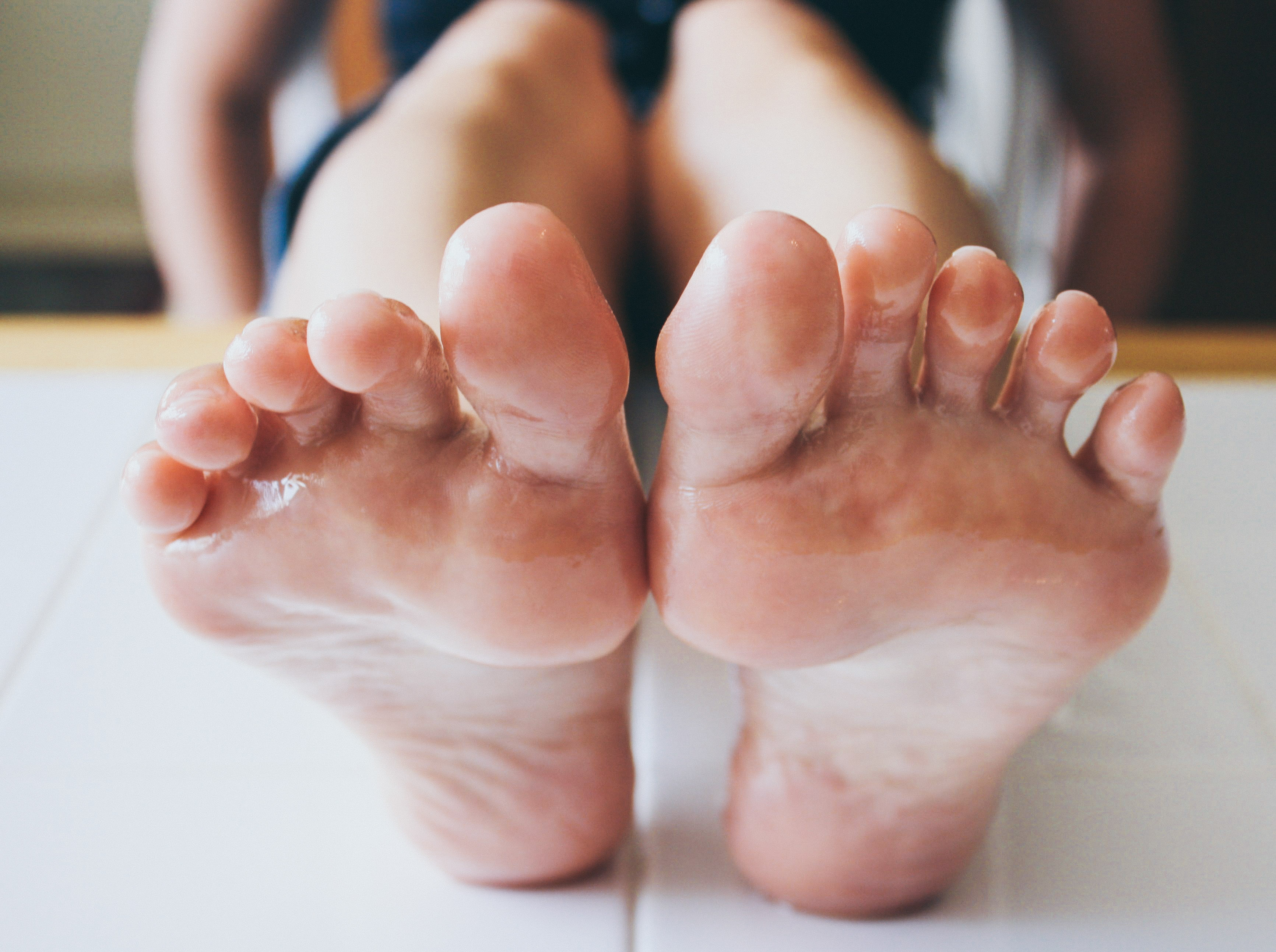 a woman's sole covered in baby oil resting on a table