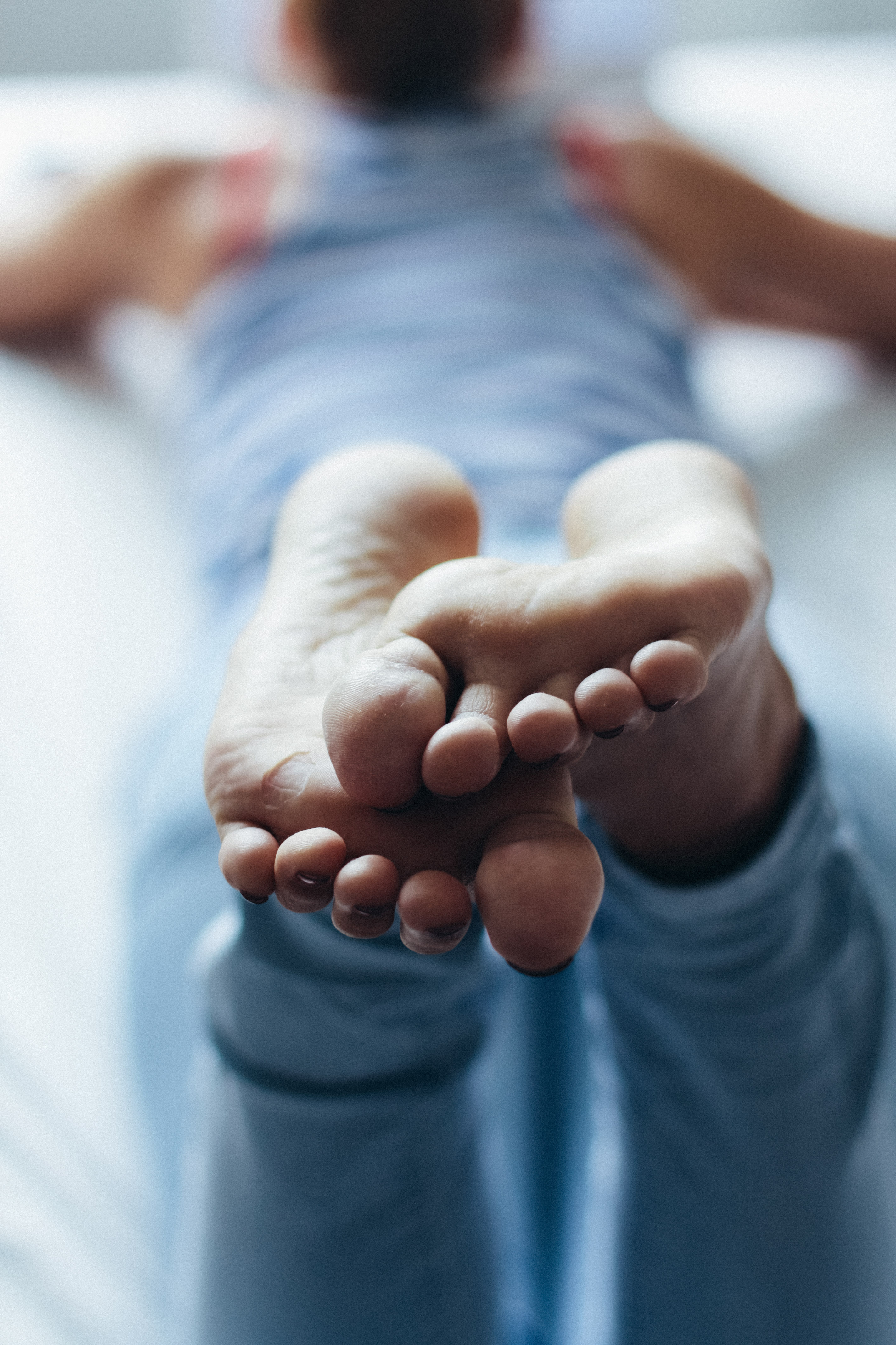 a close up of a woman's soles as she's lying on a bed