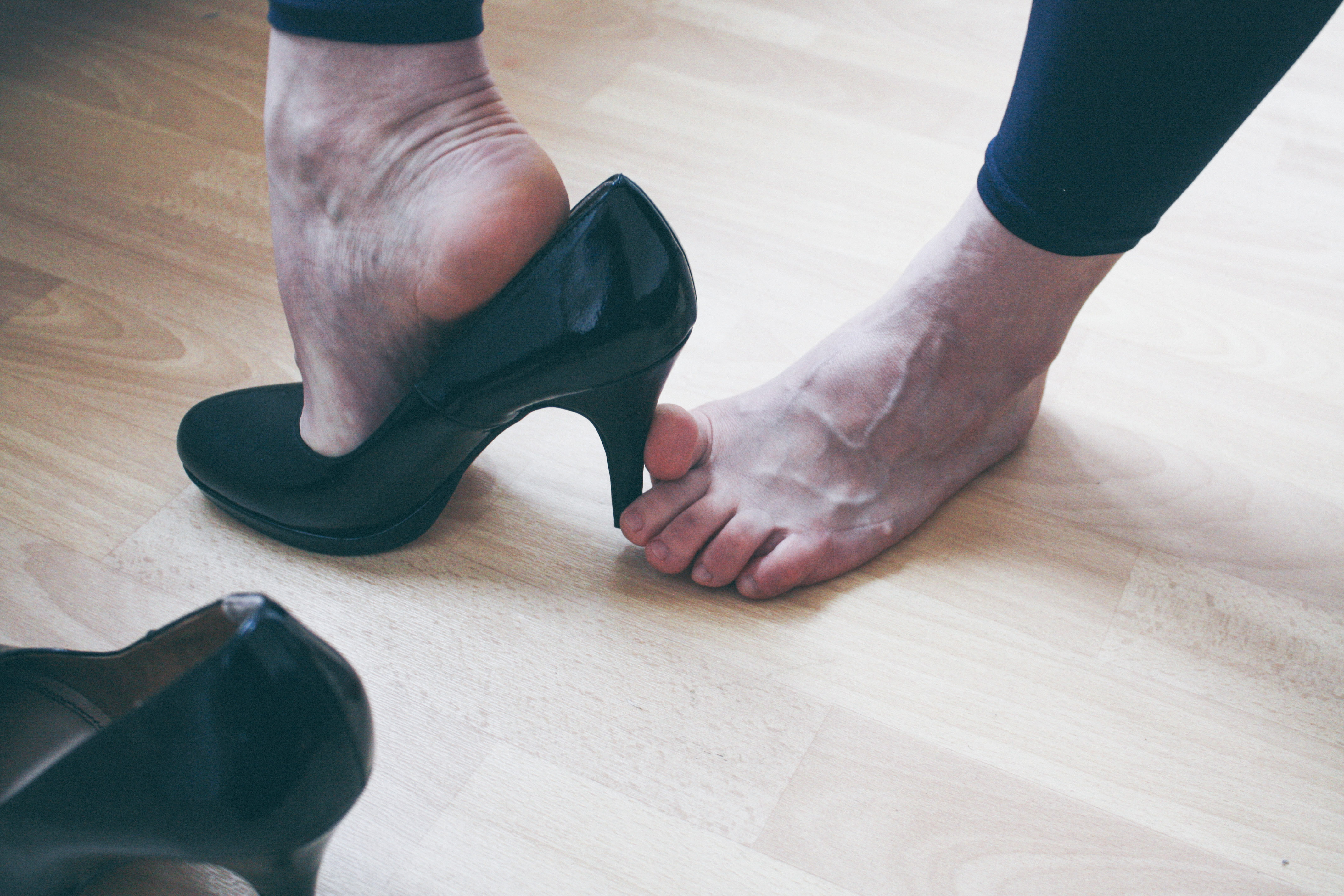 a woman removing her black high heels