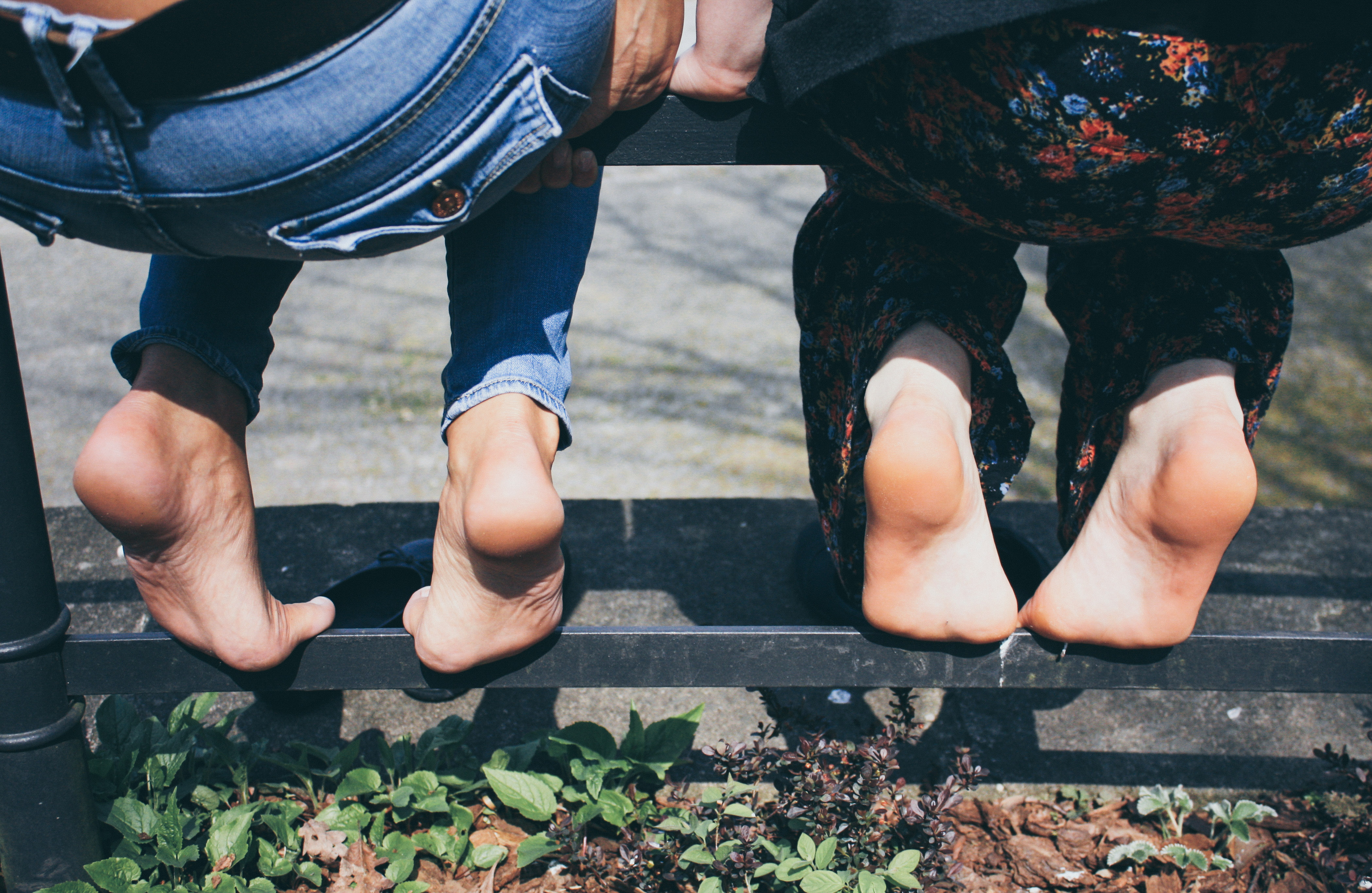 two women's soles as they sit on a metal railing in a part