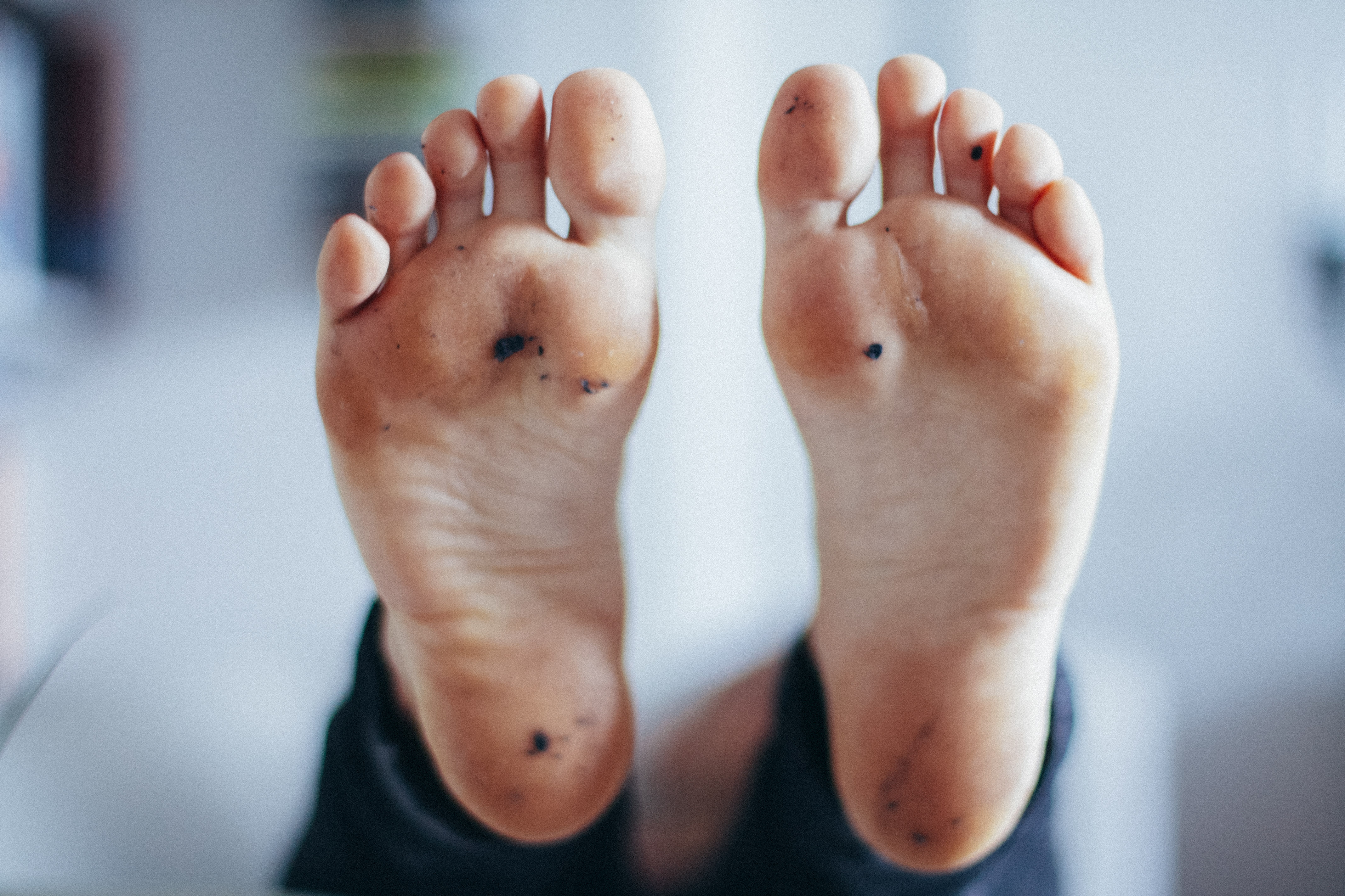 a woman's pale bare feet resting on a white plate