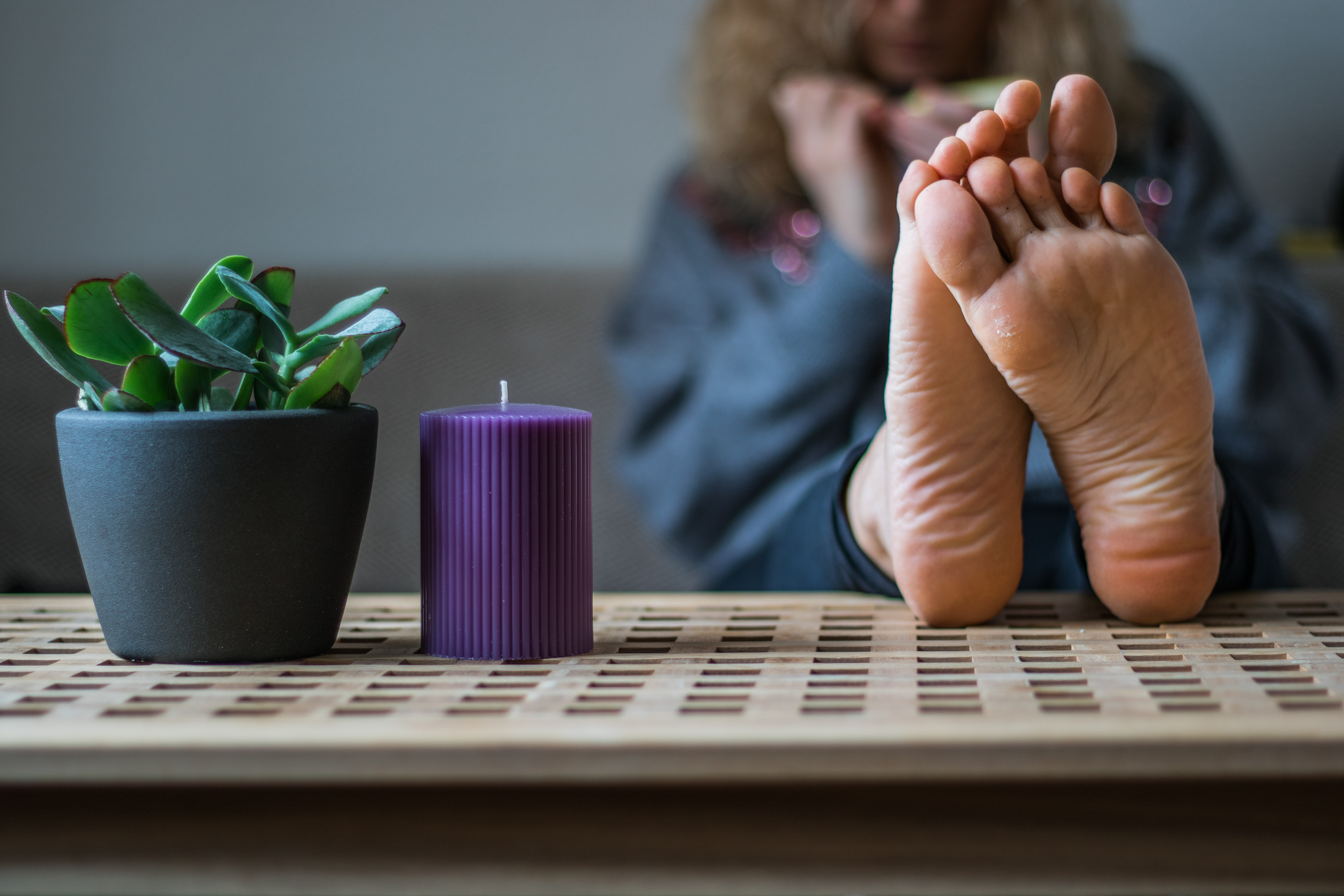 a woman's soles resting on a wooden coffee table