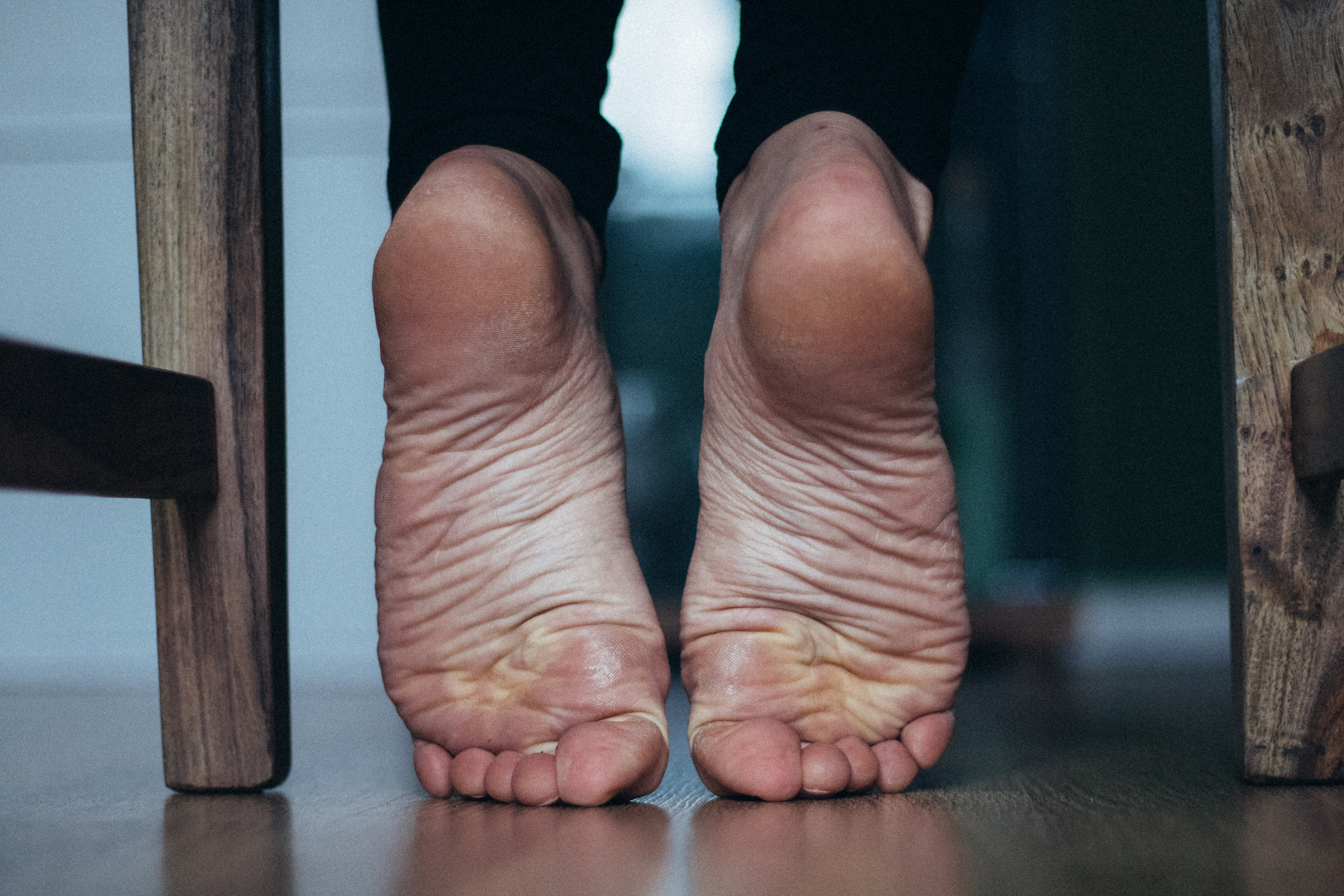 a woman's feet under a chair with her toes scrunched