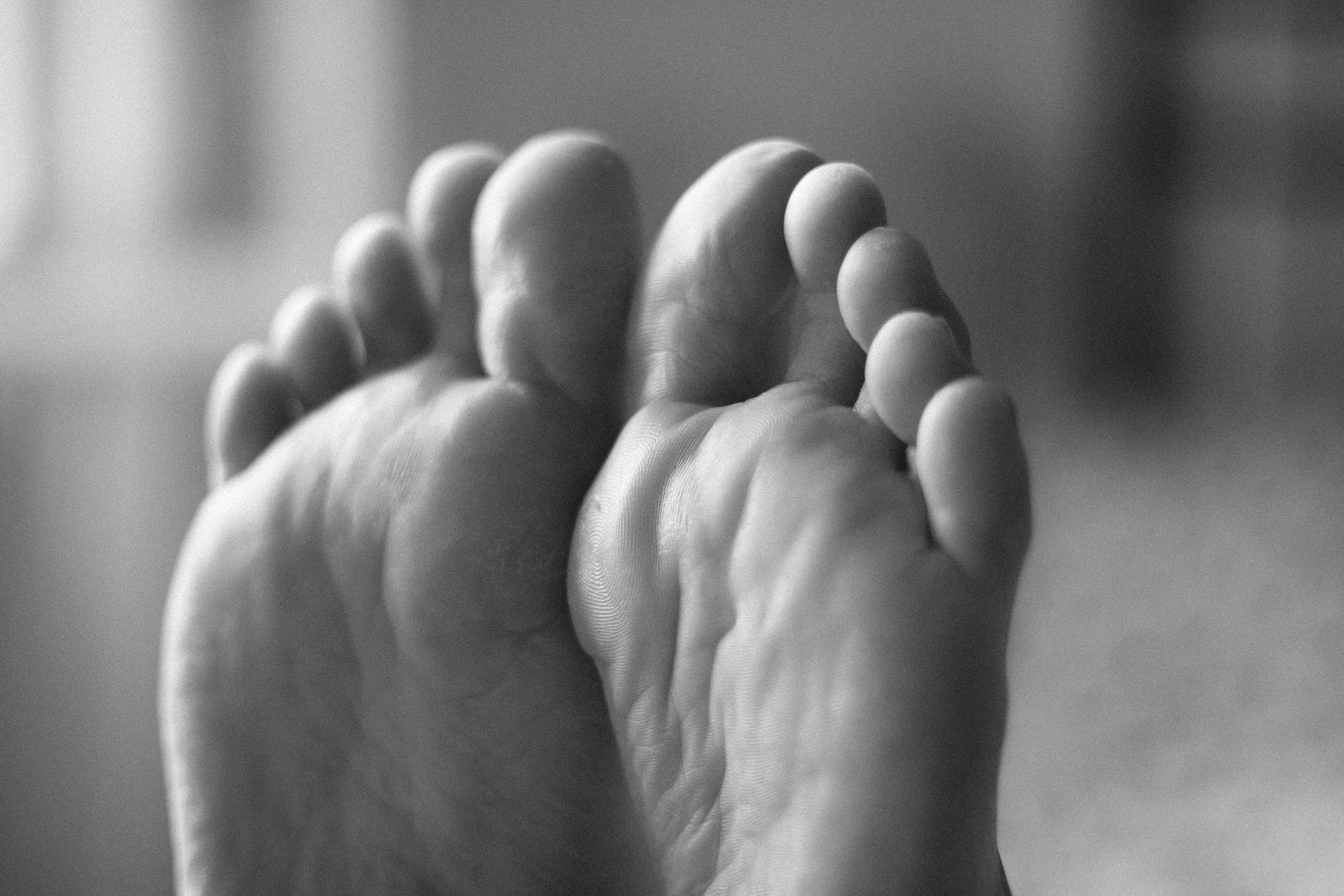 a close up of a woman's soles as she's laying on a bed