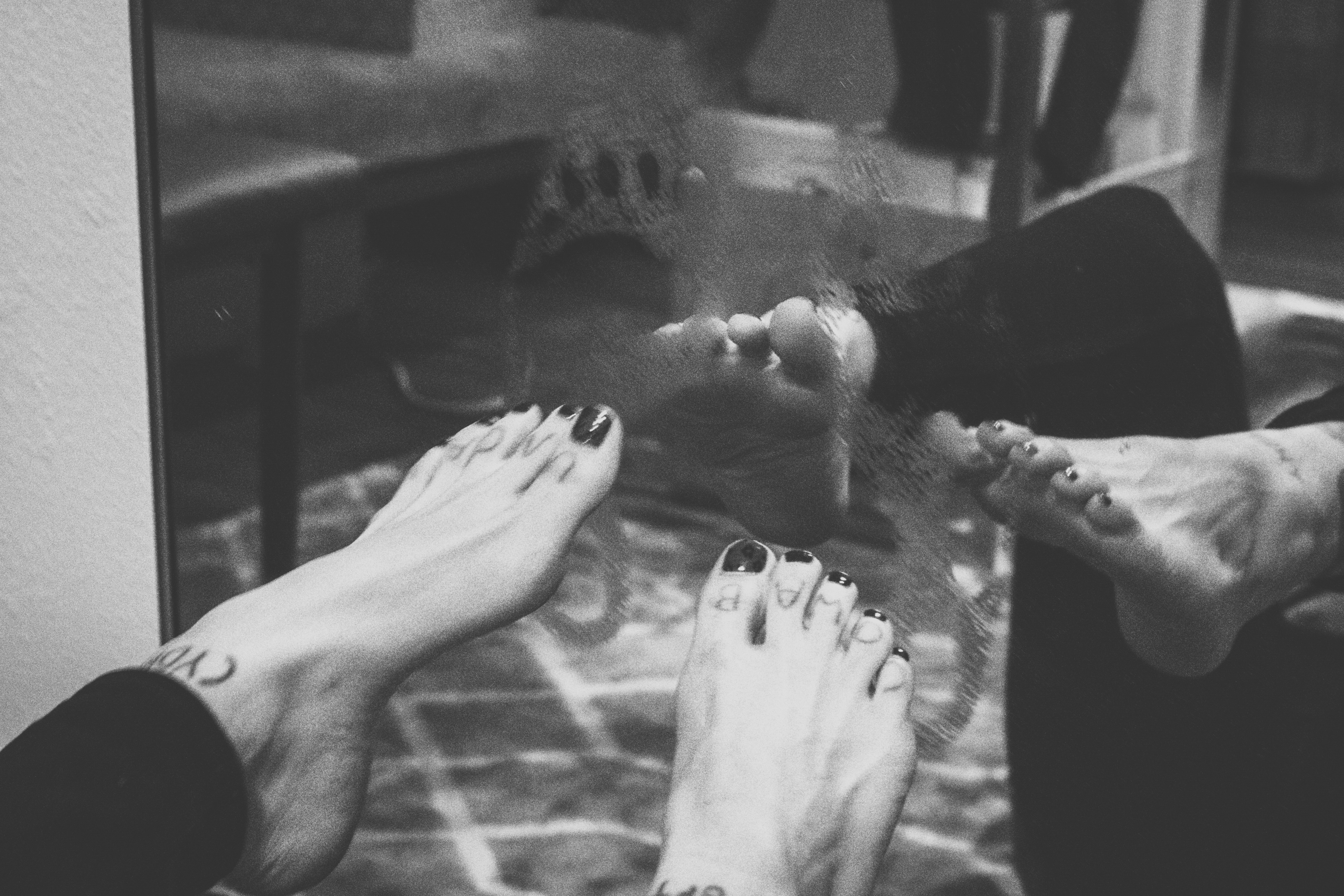 a woman's feet and her steamy foot prints on a mirror