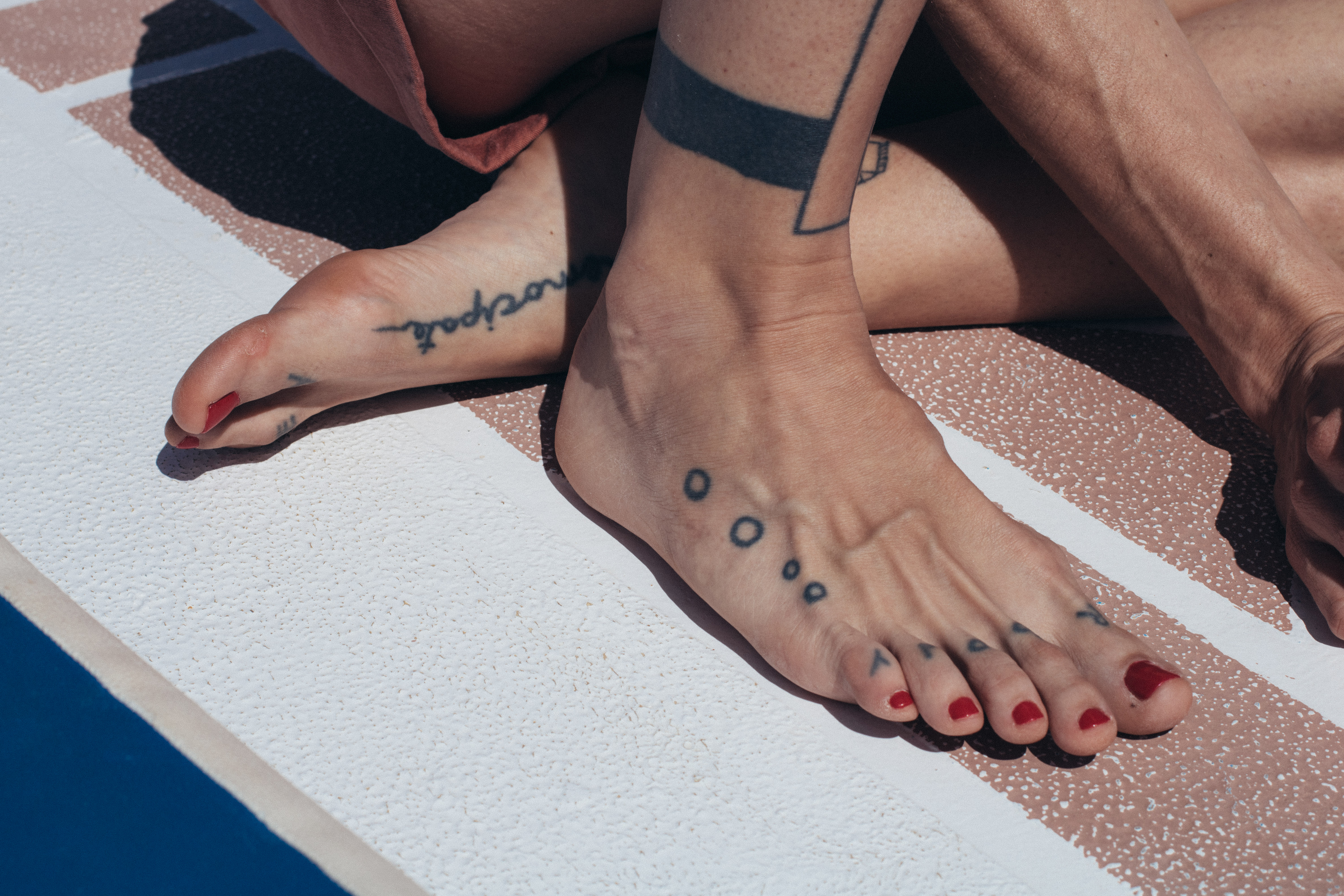 close up view of woman's toes. her nails are painted bright red.