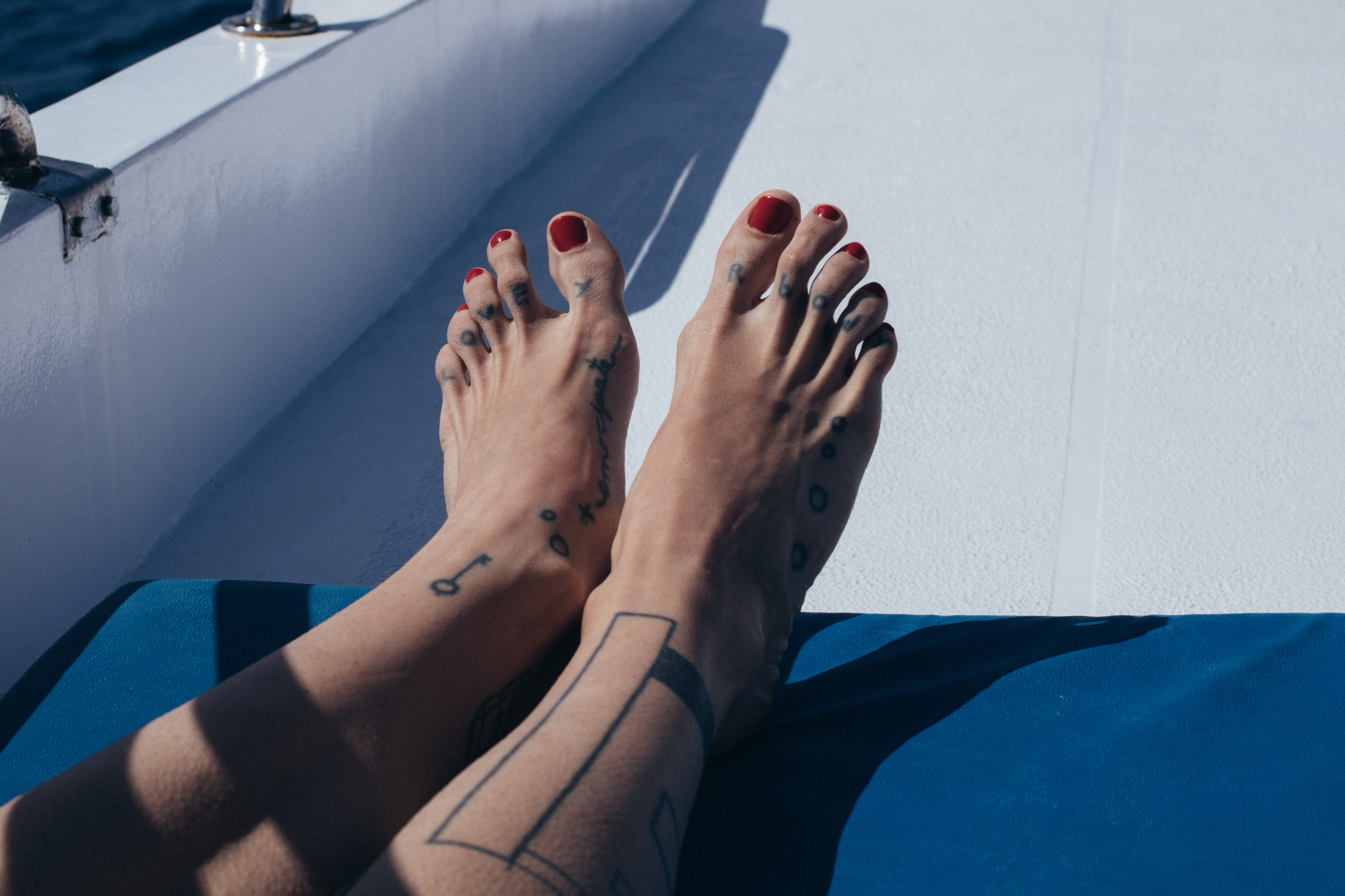 woman's legs and feet laying on royal blue mattress