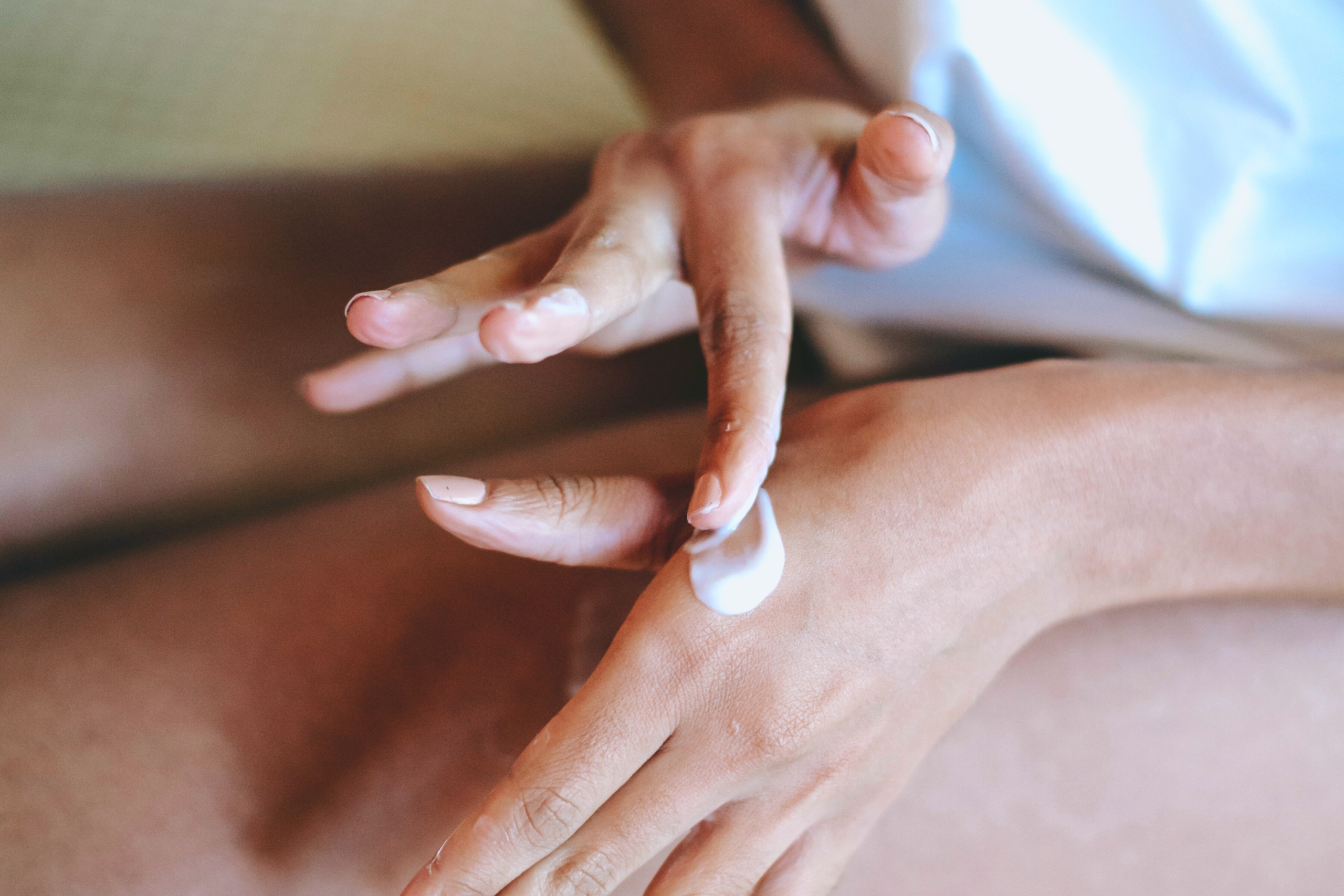 A close up of someone with moisturizer on their hand to be applied to dry skin under eyes, ears or nose