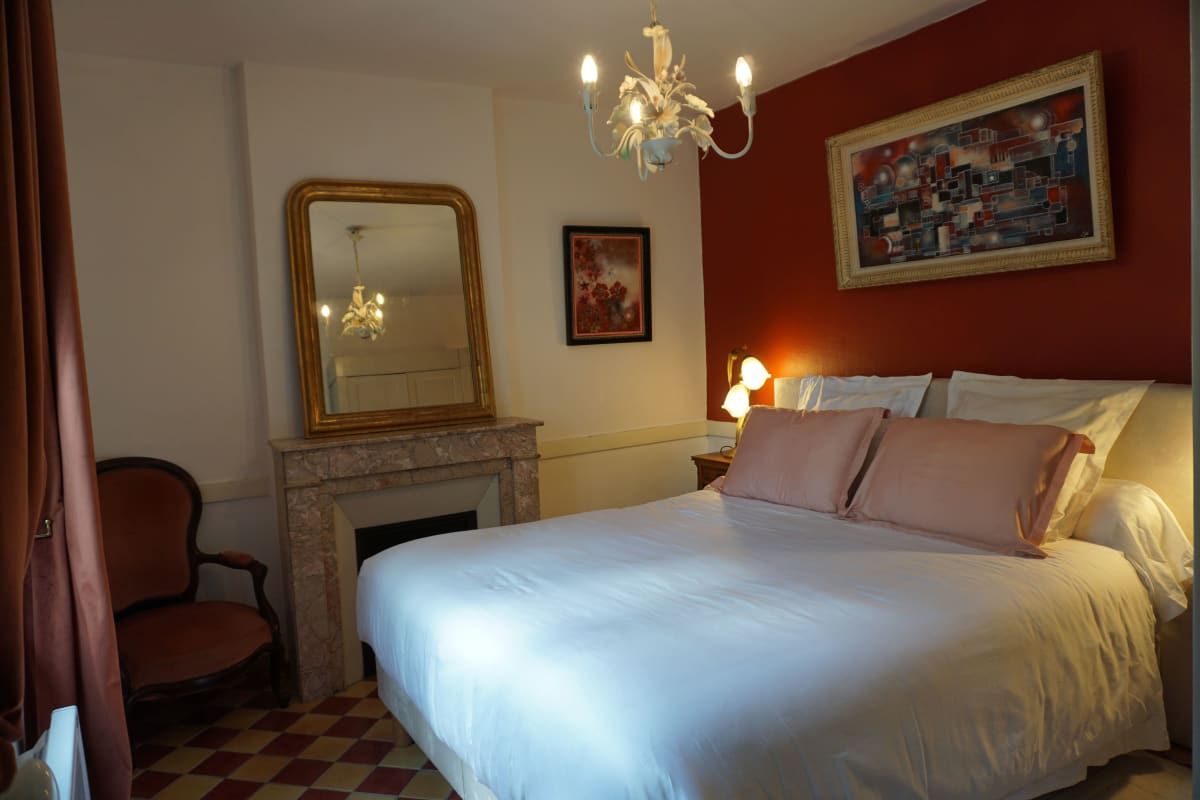 Chambre double avec cheminée en marbre, miroir doré et lustre