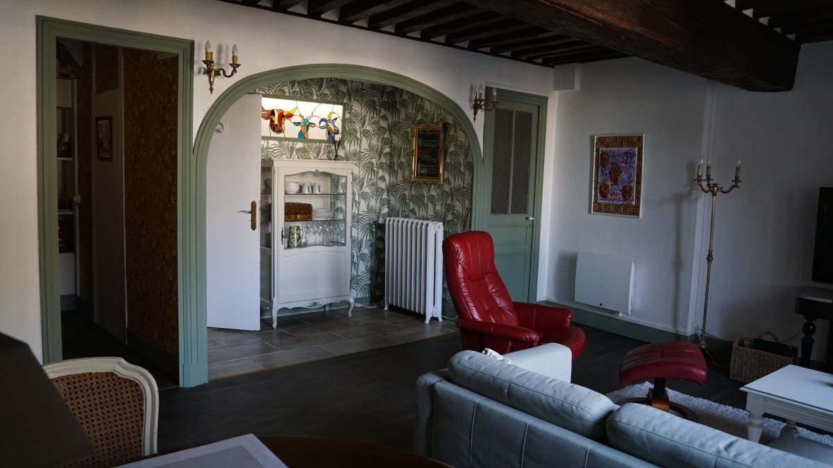 Salon avec arche sculptée et fauteuil rouge