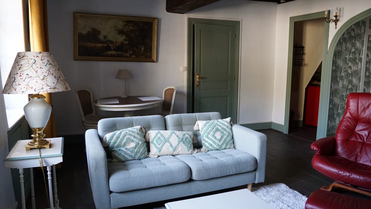 Salon avec canapé clair et mobilier de caractère