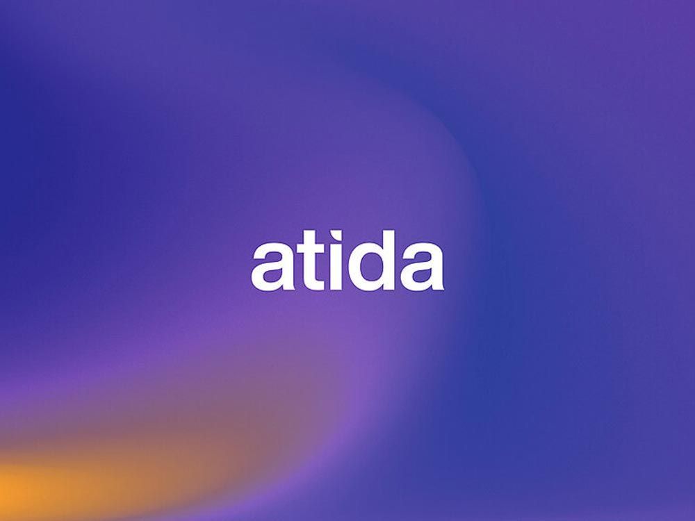 The word atida in white lettering on a blurred purple and orange gradient background.