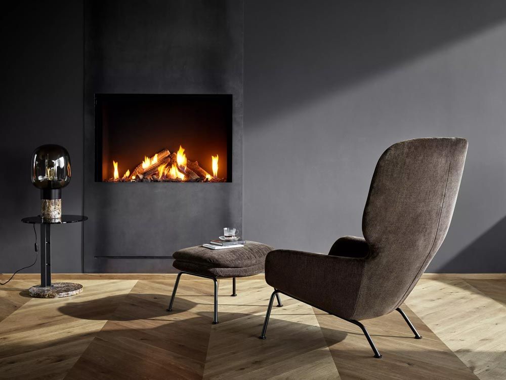 Modern living room features a built-in fireplace, stylish armchair, and wood parquet floor.