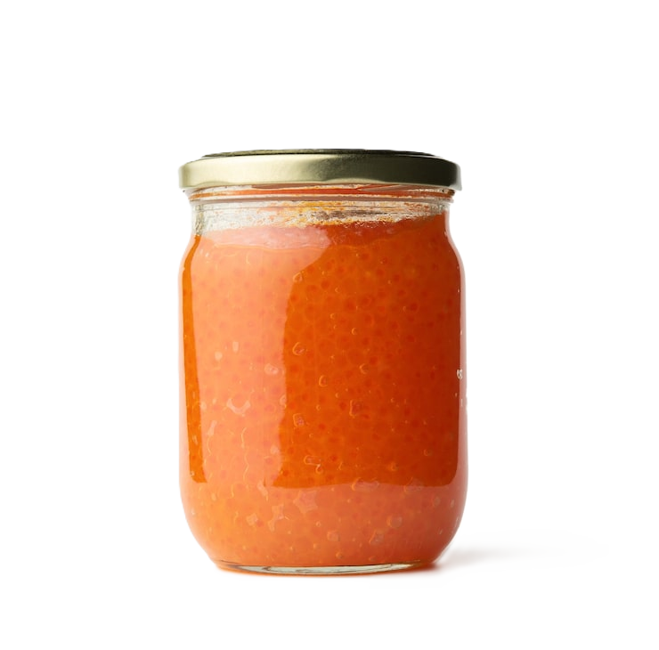 Close-up of a woman with long wavy brown hair, wearing a blue shirt and a delicate necklace, looking calmly at the camera.