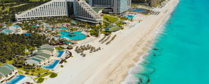 Aerial view of luxury beachfront resort with white sand beach and turquoise Caribbean waters