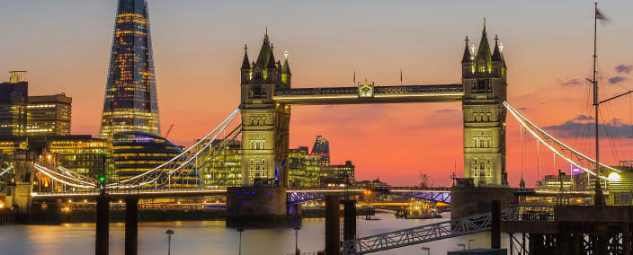 Tower Bridge and The Shard skyscraper illuminated at sunset over the Thames River in London