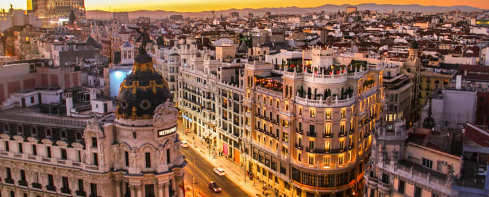 Aerial view of Madrid's Gran Via at golden hour showing historic architecture and busy street intersection