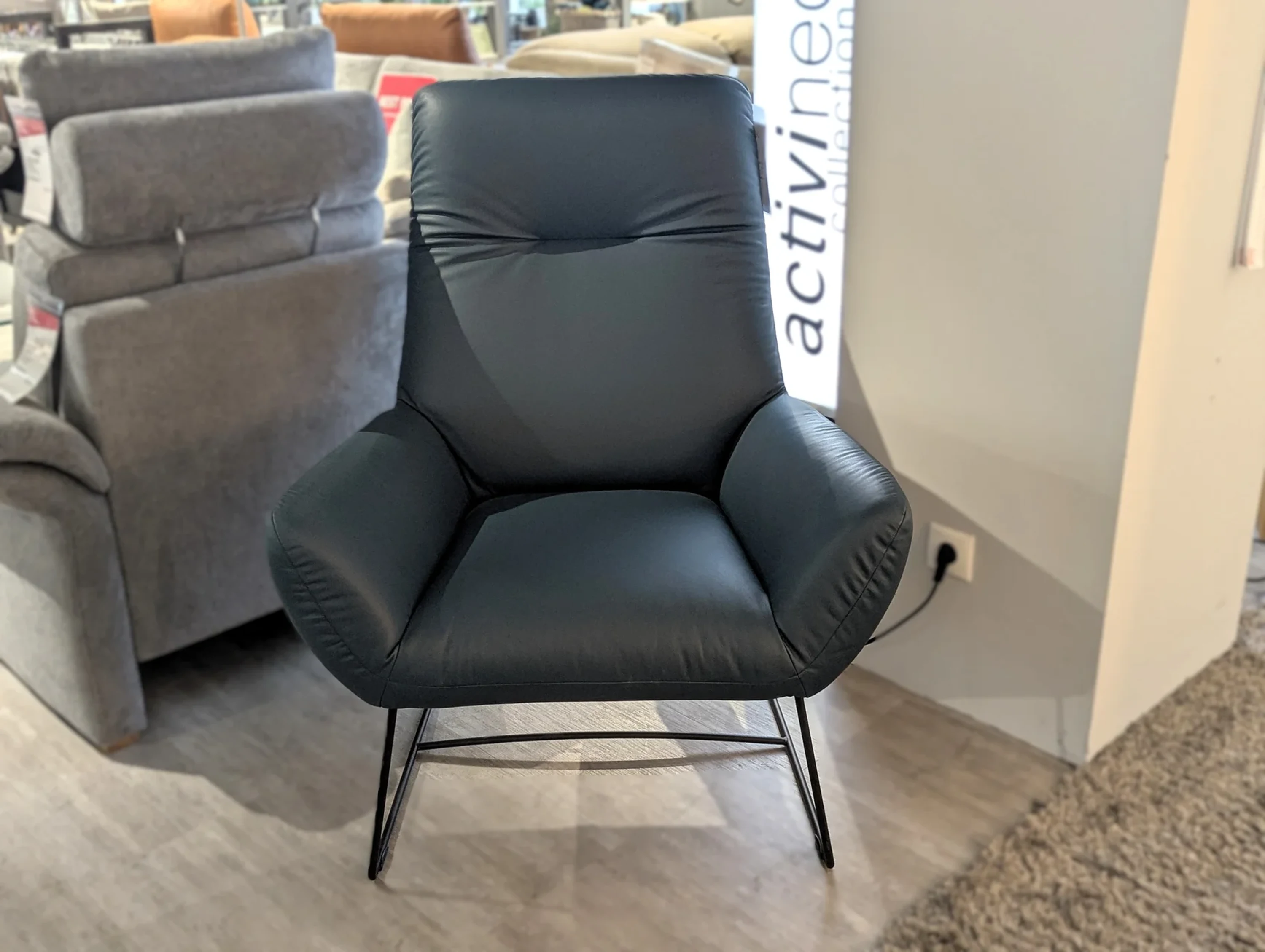 Ledersessel vor einem Sofa mit schwarzem Fuß