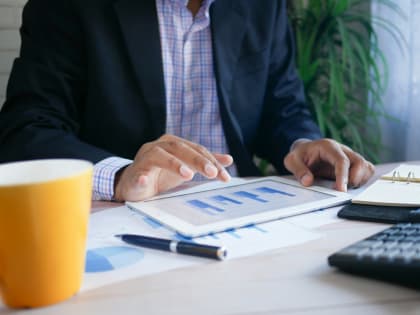 Specialist preparing financial projections with a tablet and calculator