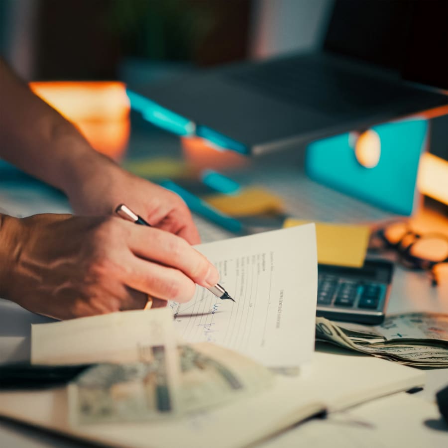 Hand signing company formation documents at a desk