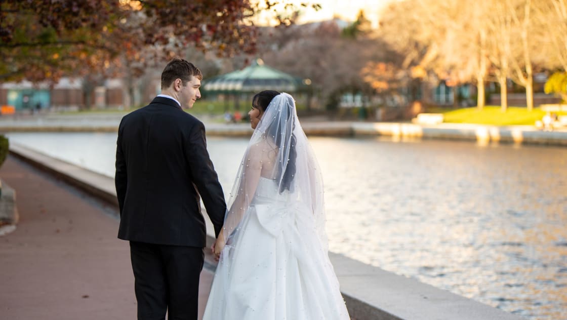 bride and groom on a stroll in front of river