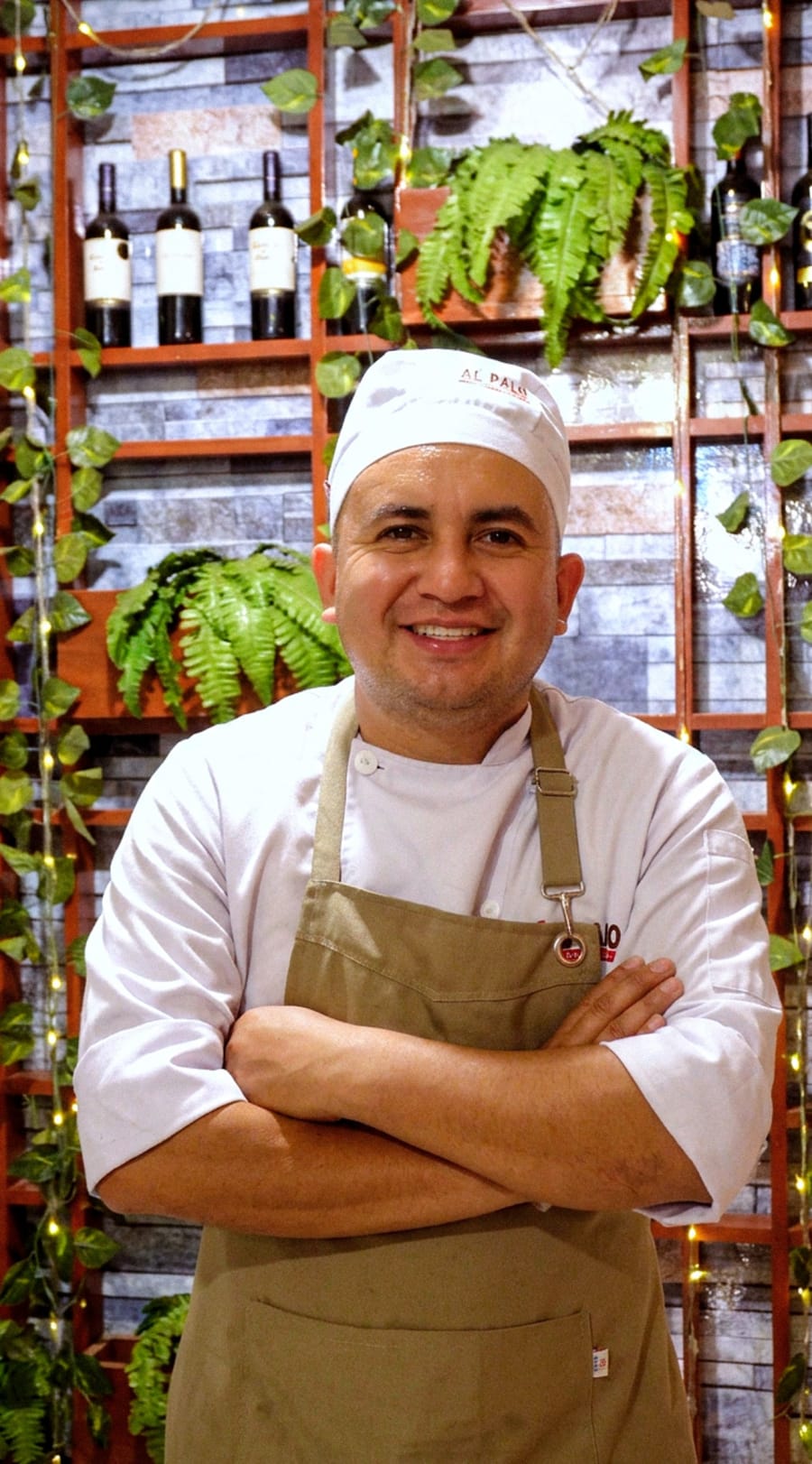 Chef de Al Palo en el comedor del restaurante, entre plantas y botellas de vino