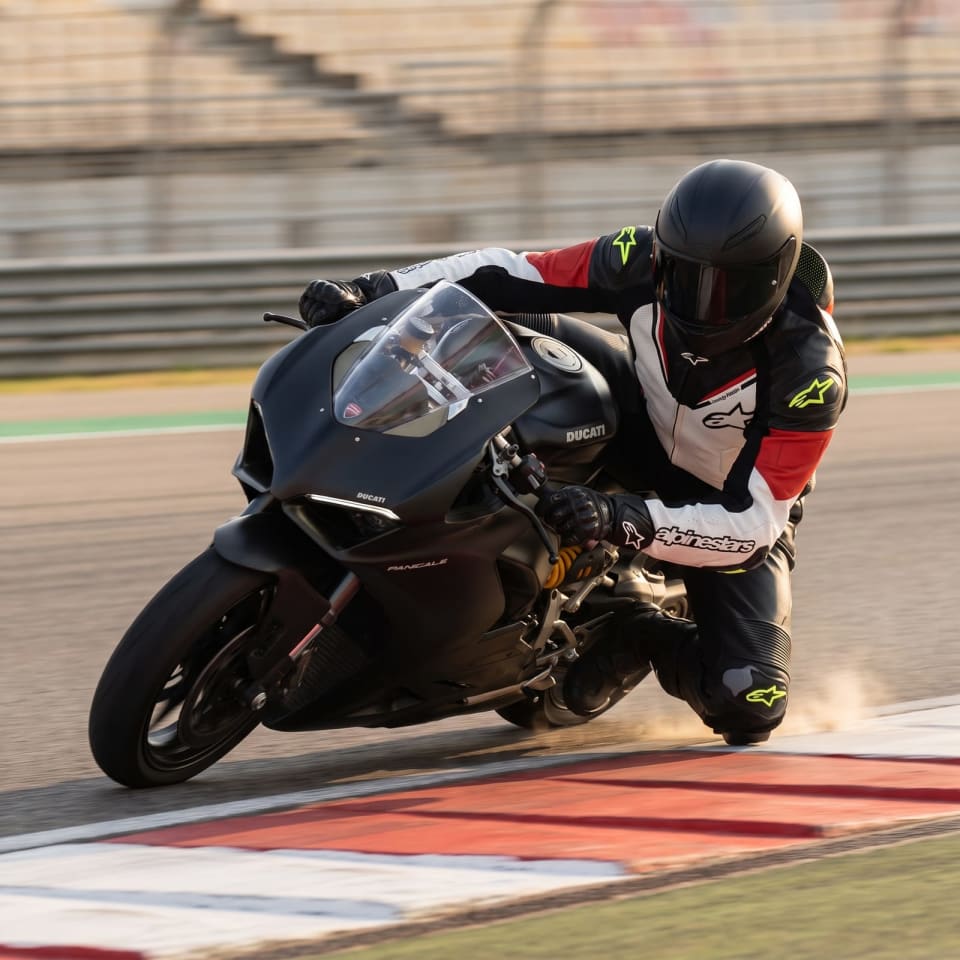 Mono Alpinestars Negro/Blanco/Rojo: piloto en pista con el equipo puesto