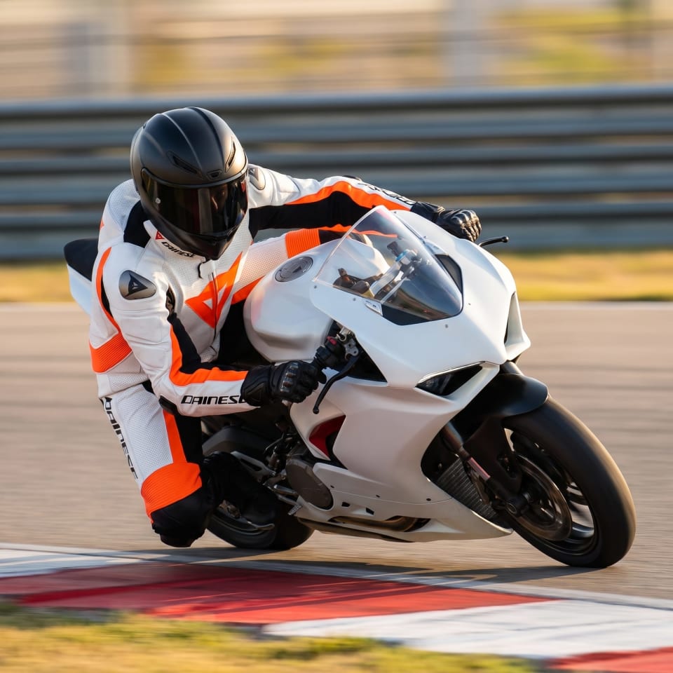 Mono Dainese Blanco/Naranja Flúor: piloto en pista con el equipo puesto