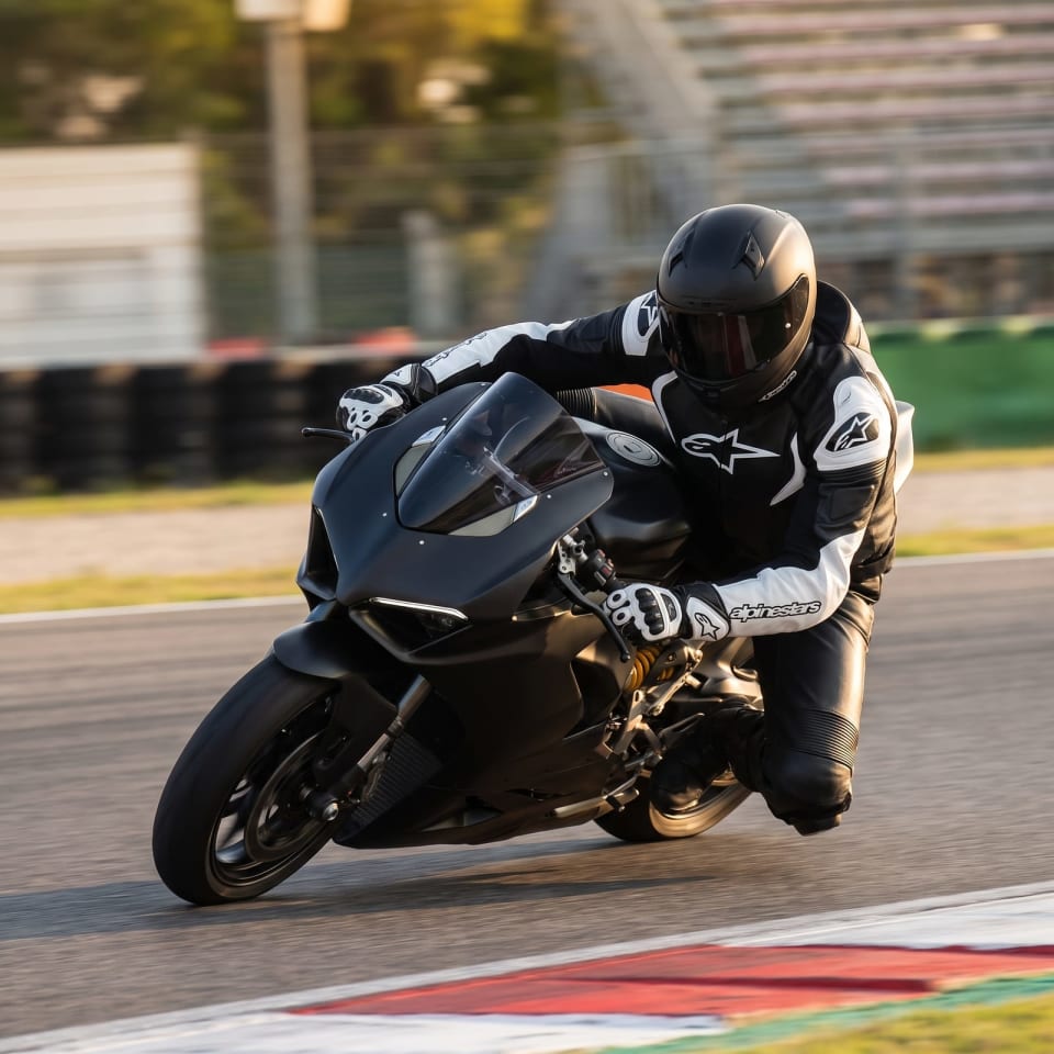 Chaqueta Alpinestars Negro/Blanco + Guantes: piloto en pista con el equipo puesto